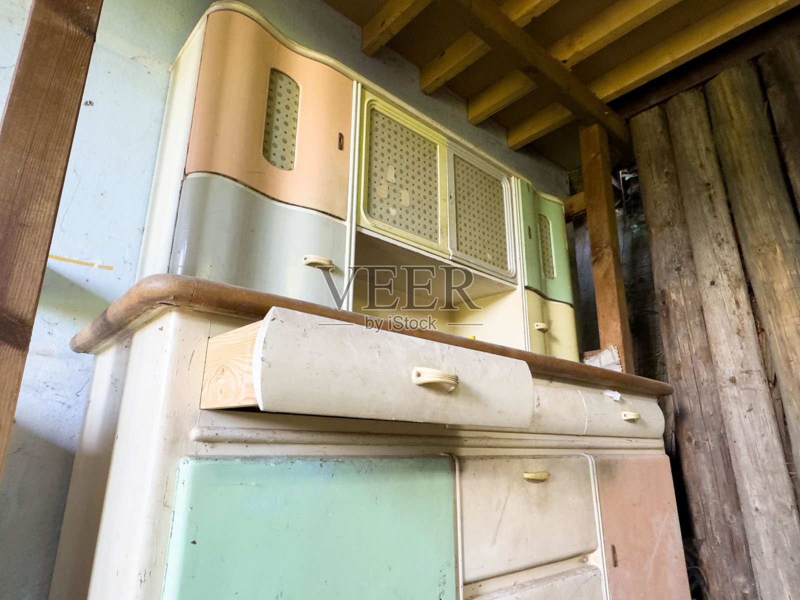 复古的粉彩厨房橱柜，配有木质台面，置于乡村风格的环境中照片摄影图片