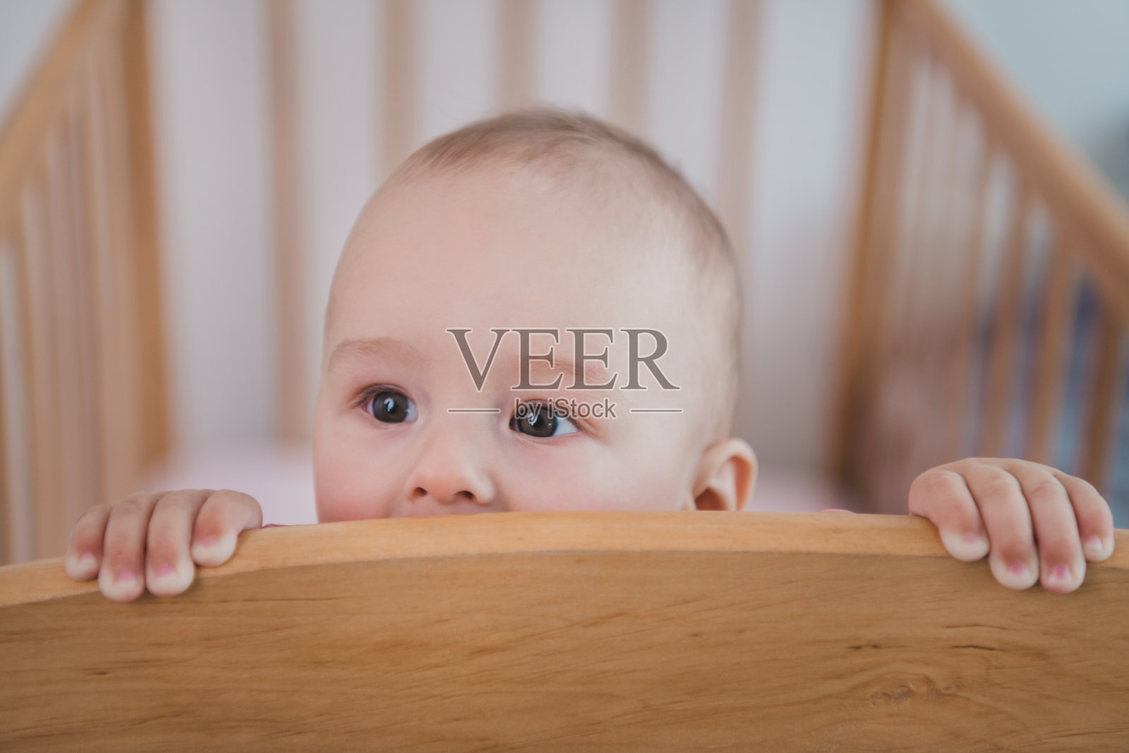 可爱有趣的小孩躺在木床上寻找妈妈，室内房间。照片摄影图片