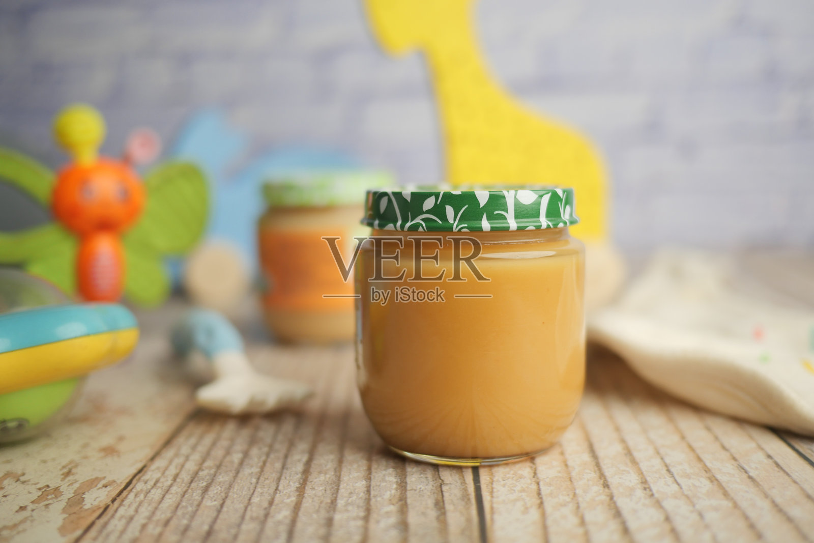 木桌上摆放着婴儿食品罐和玩具照片摄影图片