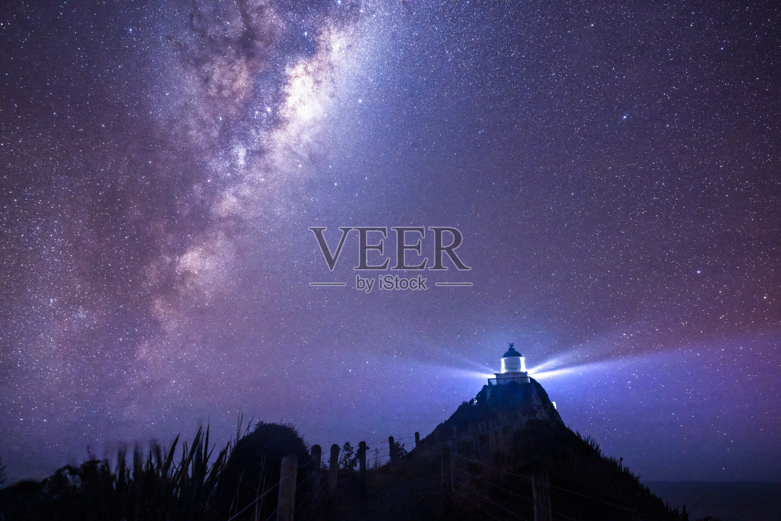 南方的纳格特角灯塔上空的银河。新西兰。照片摄影图片
