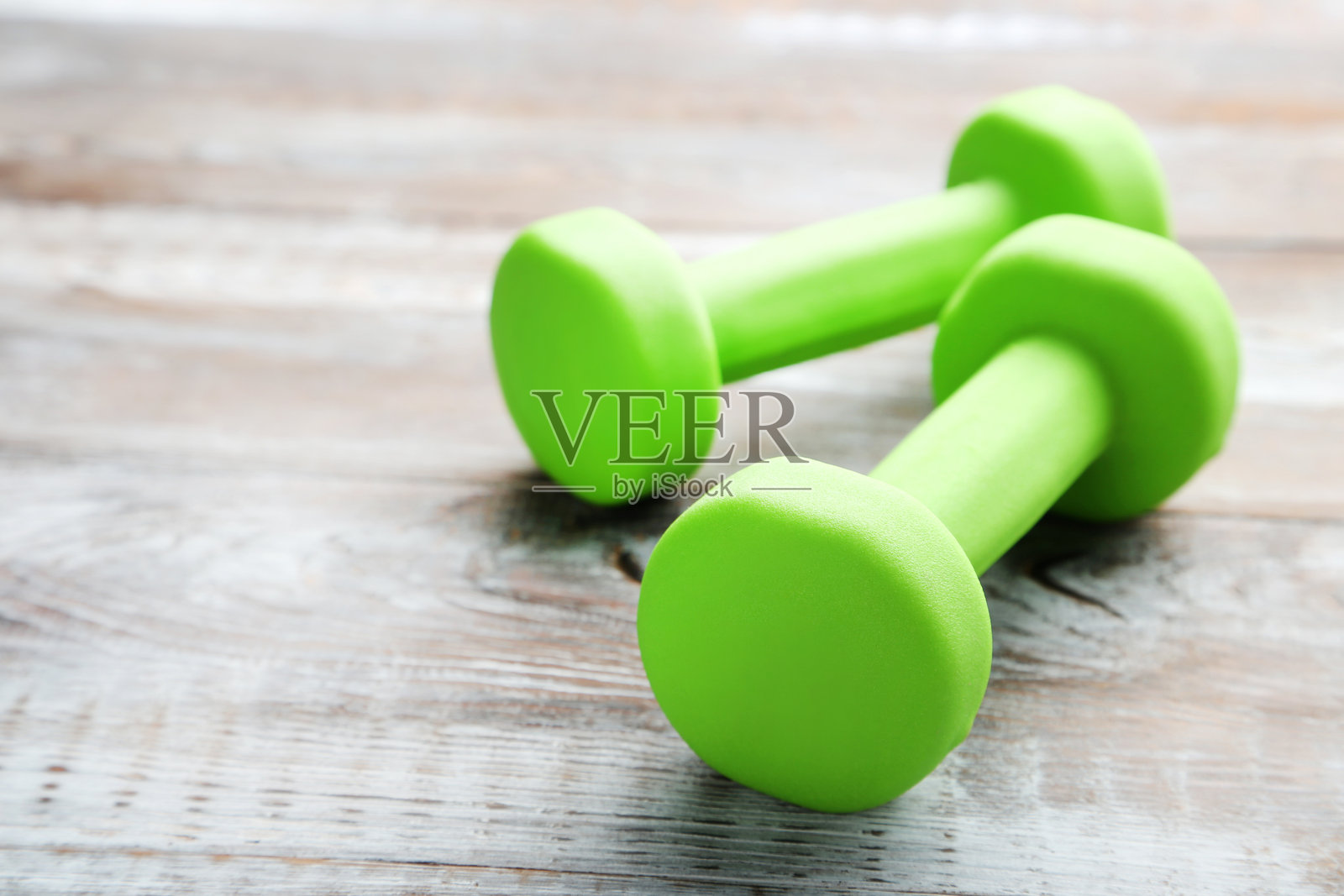 灰色木桌上的绿色哑铃照片摄影图片
