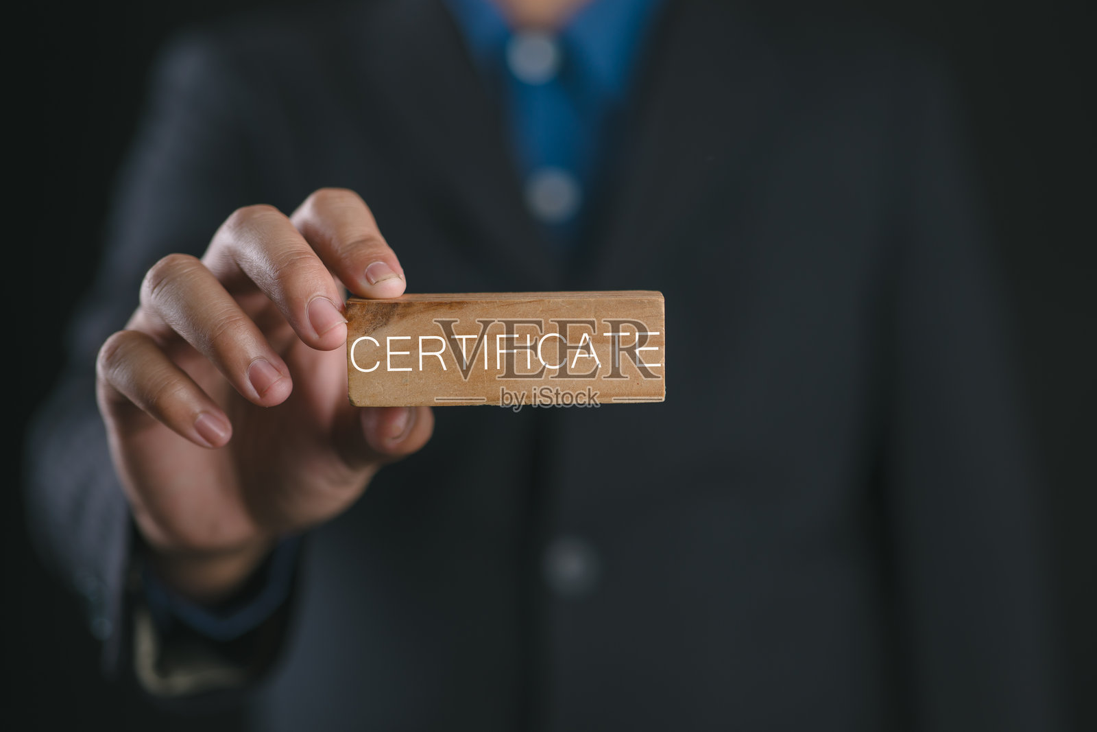 ISO标准认证与质量控制，国际标准化组织，商人手持带有质量保证或产品保证文本的木块。照片摄影图片