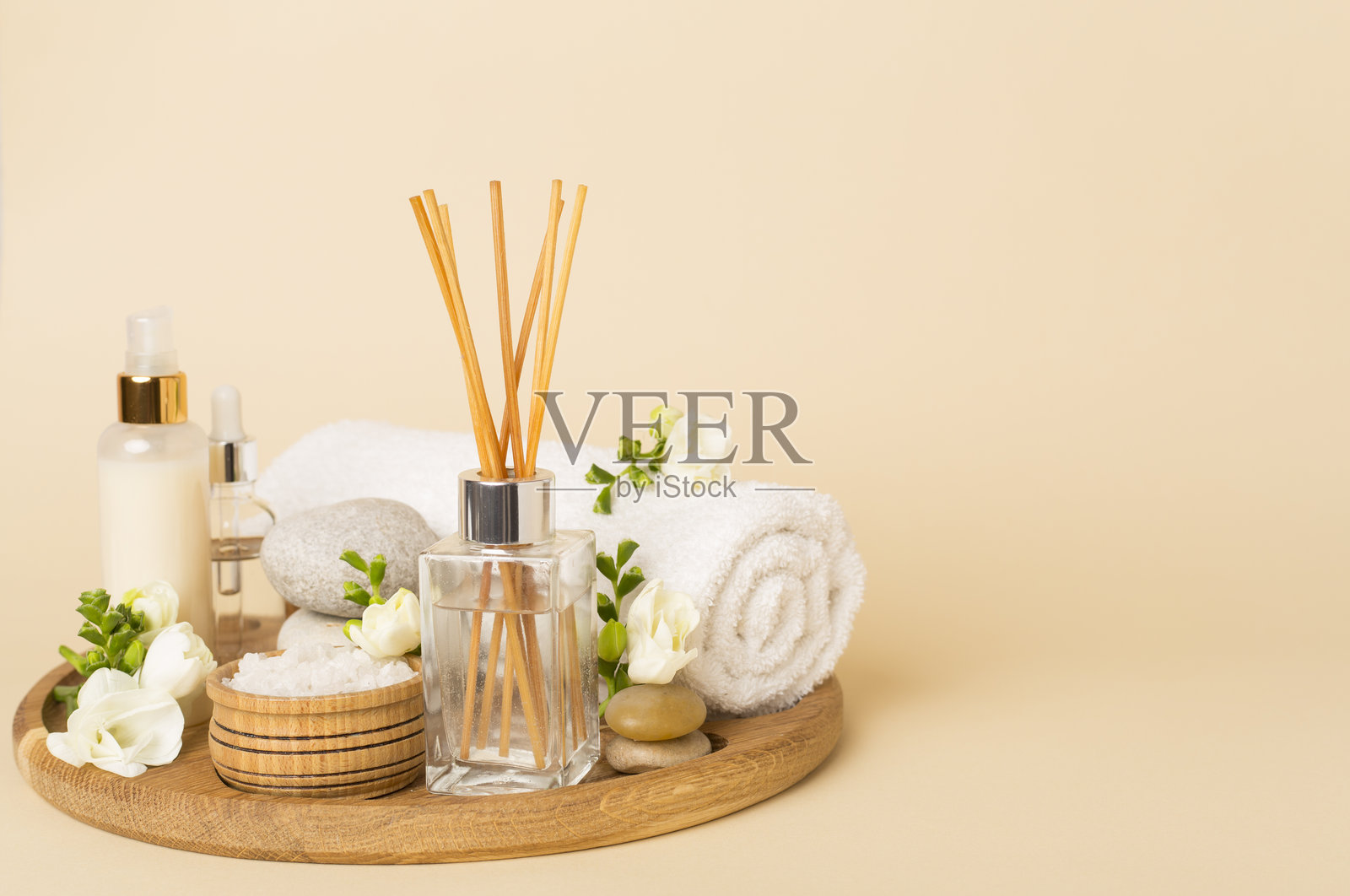 带有香豌豆花和香薰扩散器的水疗组合，背景为彩色。照片摄影图片