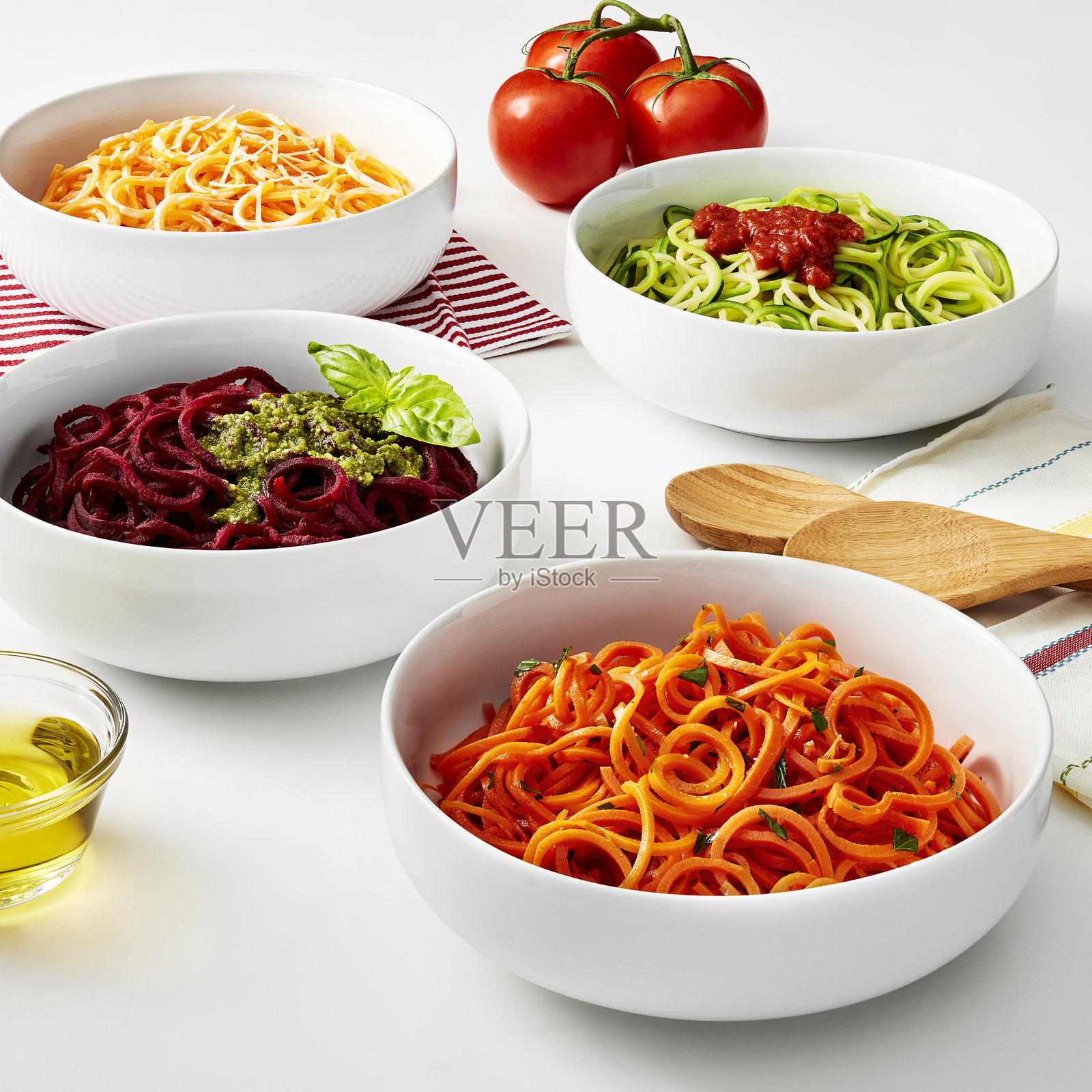 五彩缤纷的螺旋状蔬菜面条配上各种酱汁的碗照片摄影图片