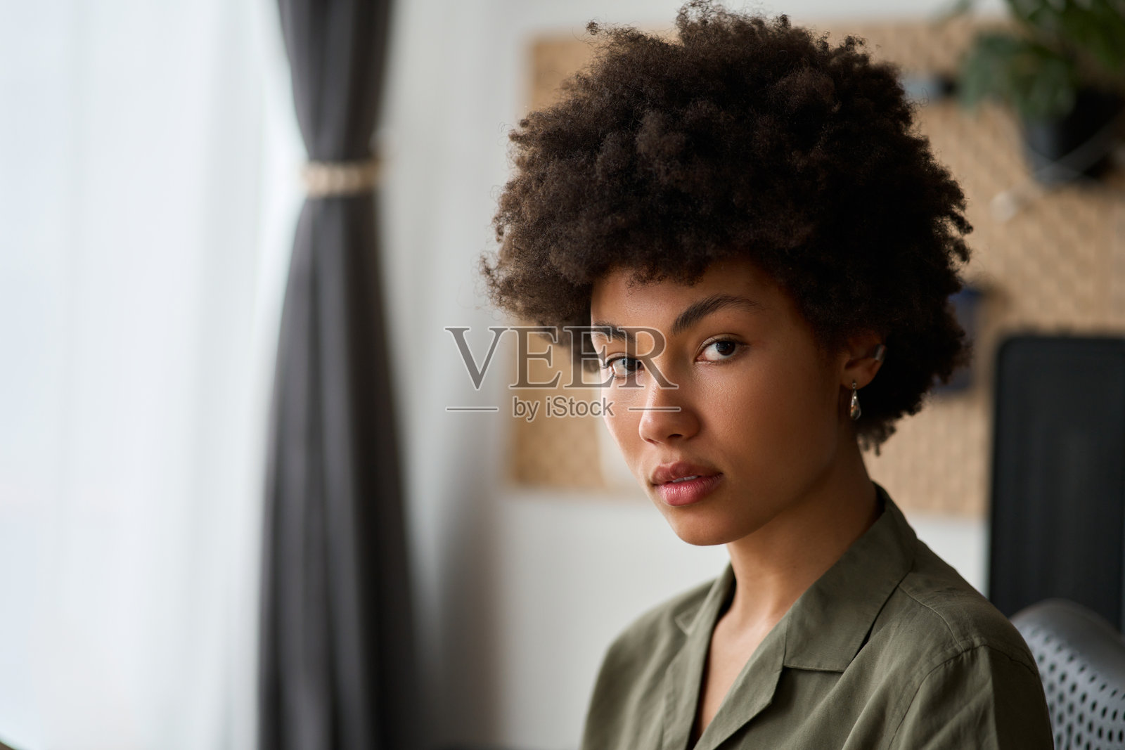 年轻漂亮的非洲女孩学生坐在家中，特写头像肖像。照片摄影图片