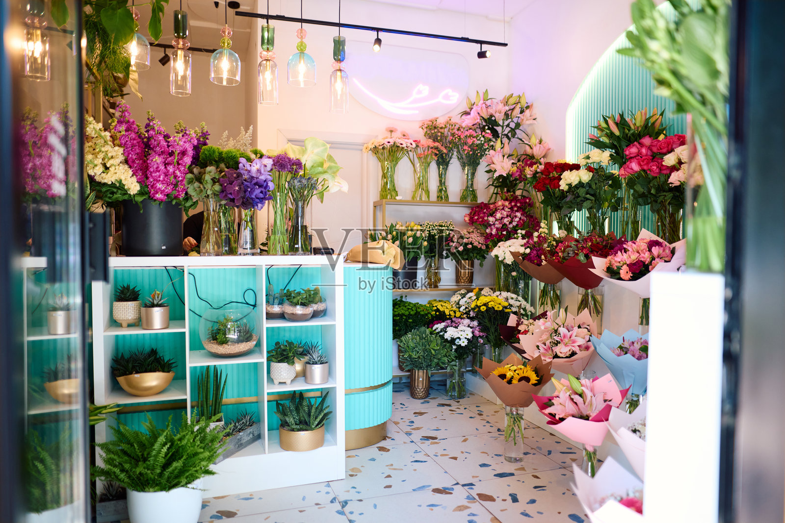 花店出售色彩缤纷的花束和室内植物，花店老板正在工作照片摄影图片