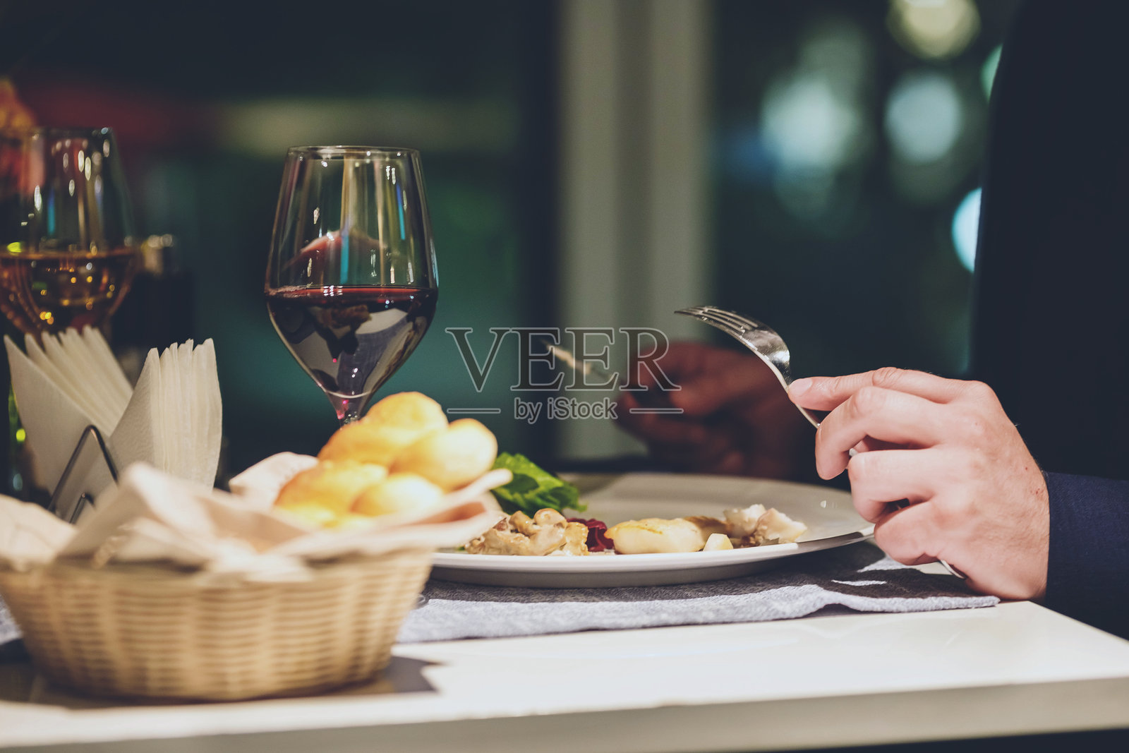 男人在餐厅的桌子上享用精致的高级美食。照片摄影图片