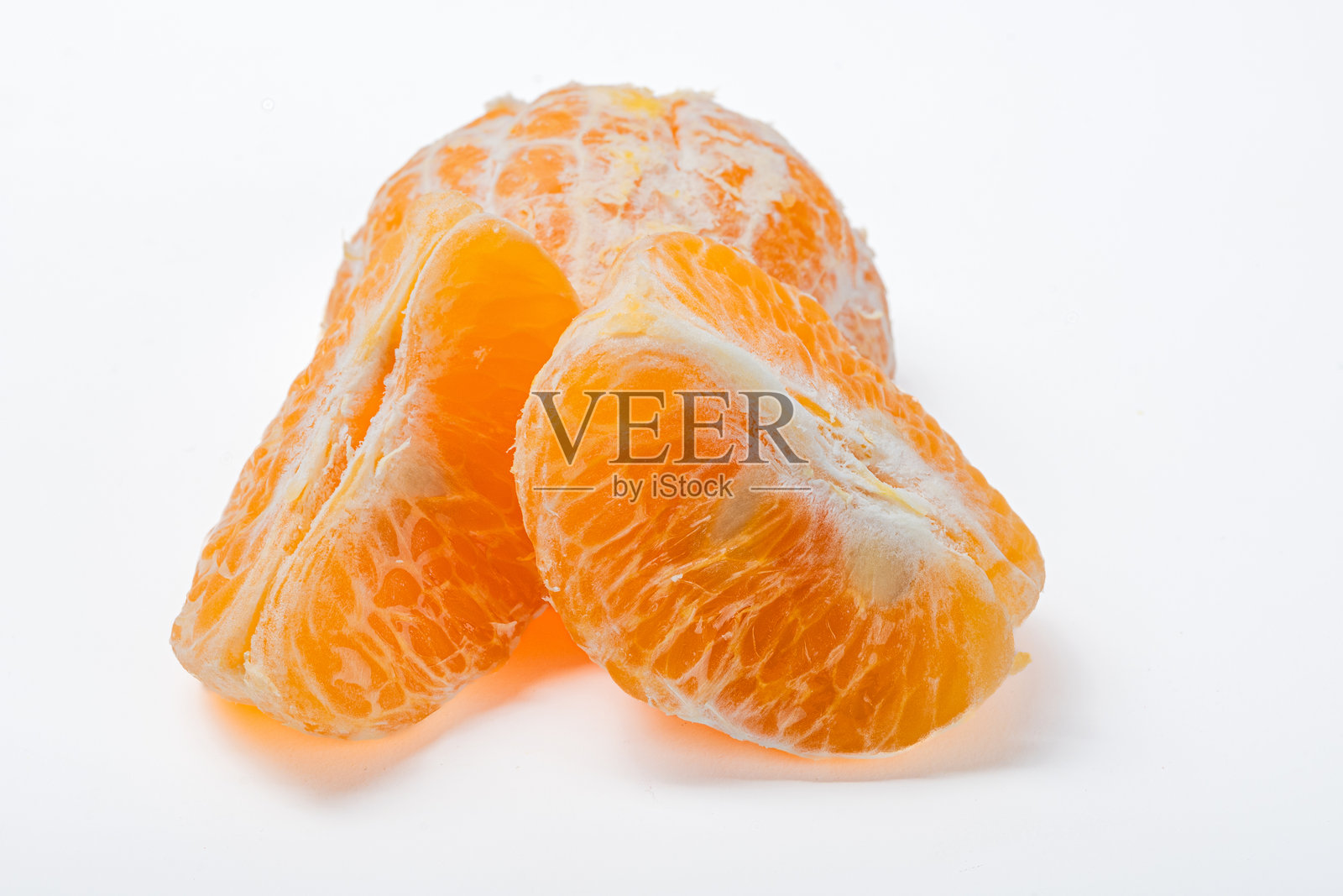 剥皮的橙子果肉分开放置在干净的白色表面上，背景明亮，突显出多汁的质地、鲜艳的颜色和柑橘水果的自然新鲜感。照片摄影图片