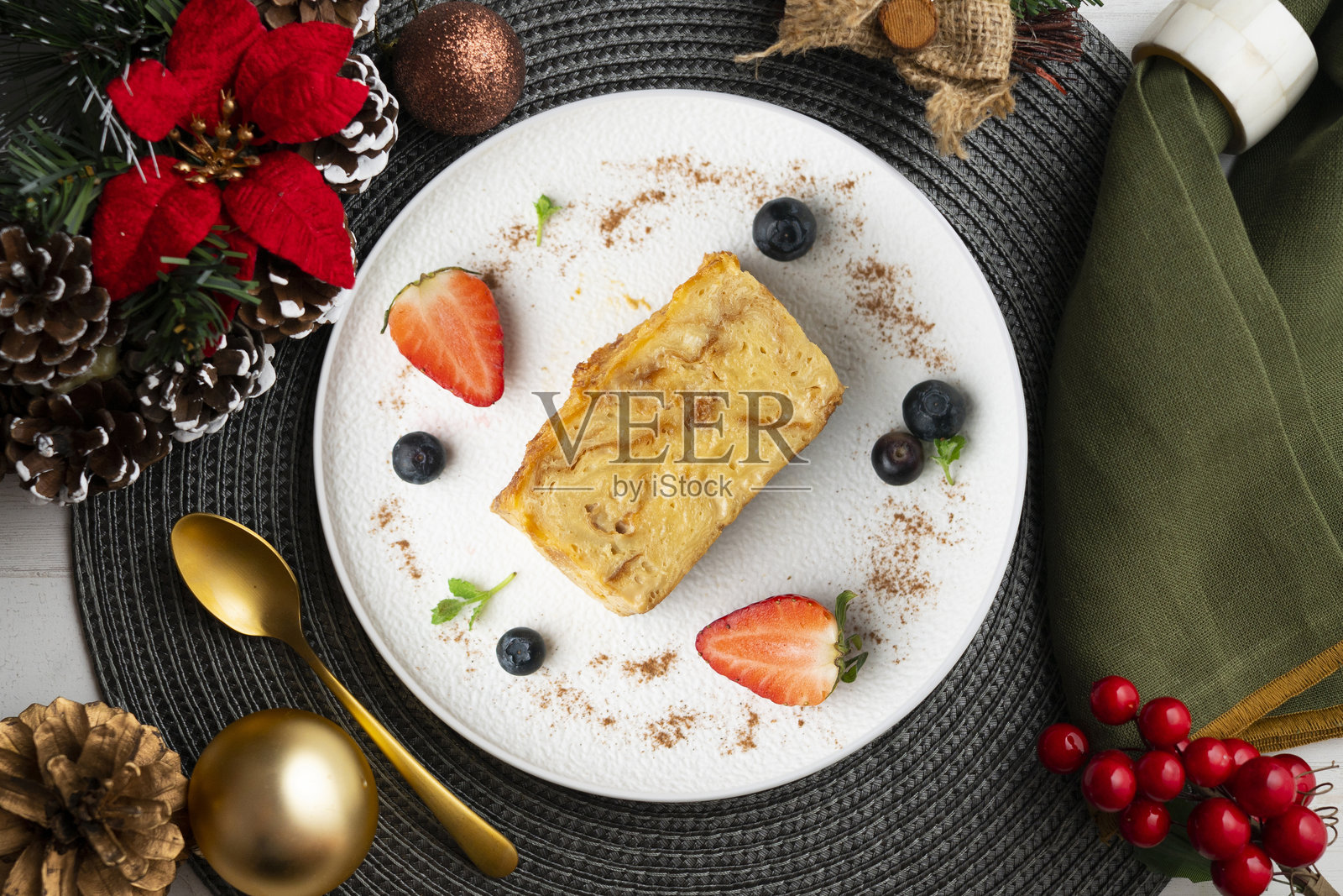 伊比萨岛的格雷克索纳。用巴利阿里群岛传统的恩赛马达制作的蛋奶布丁。顶部视角的桌子上摆放着圣诞装饰。照片摄影图片