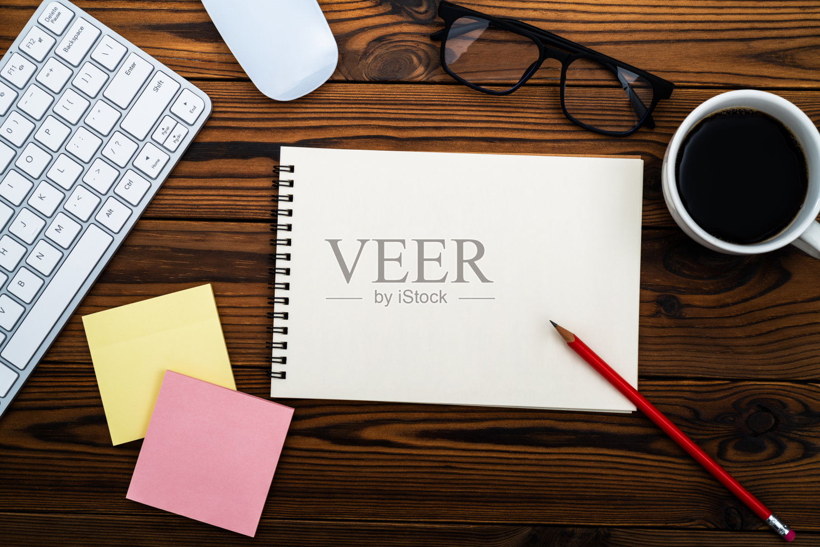 现代办公室桌面的俯视图，配有电脑键盘、空白笔记本和其他办公用品照片摄影图片