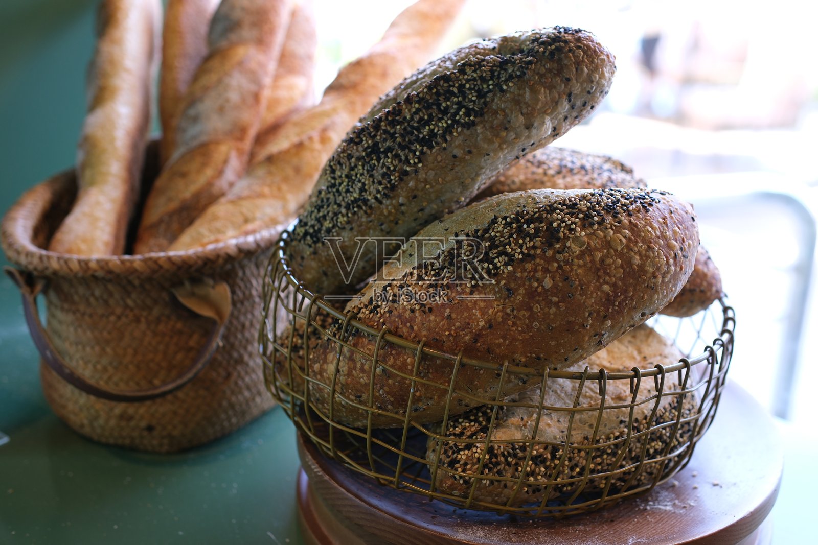 面包篮中的法棍 新鲜面包的柳条篮放在木桌上照片摄影图片