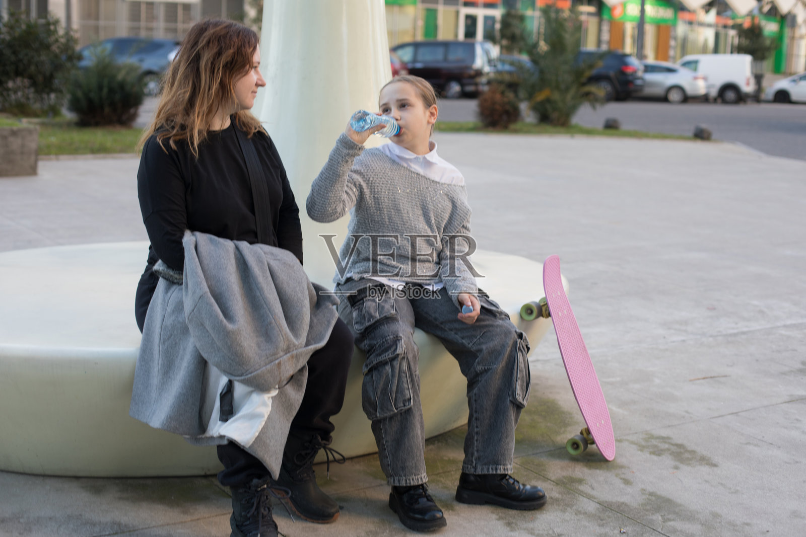 休息中的家庭。女儿和母亲在户外喝水照片摄影图片