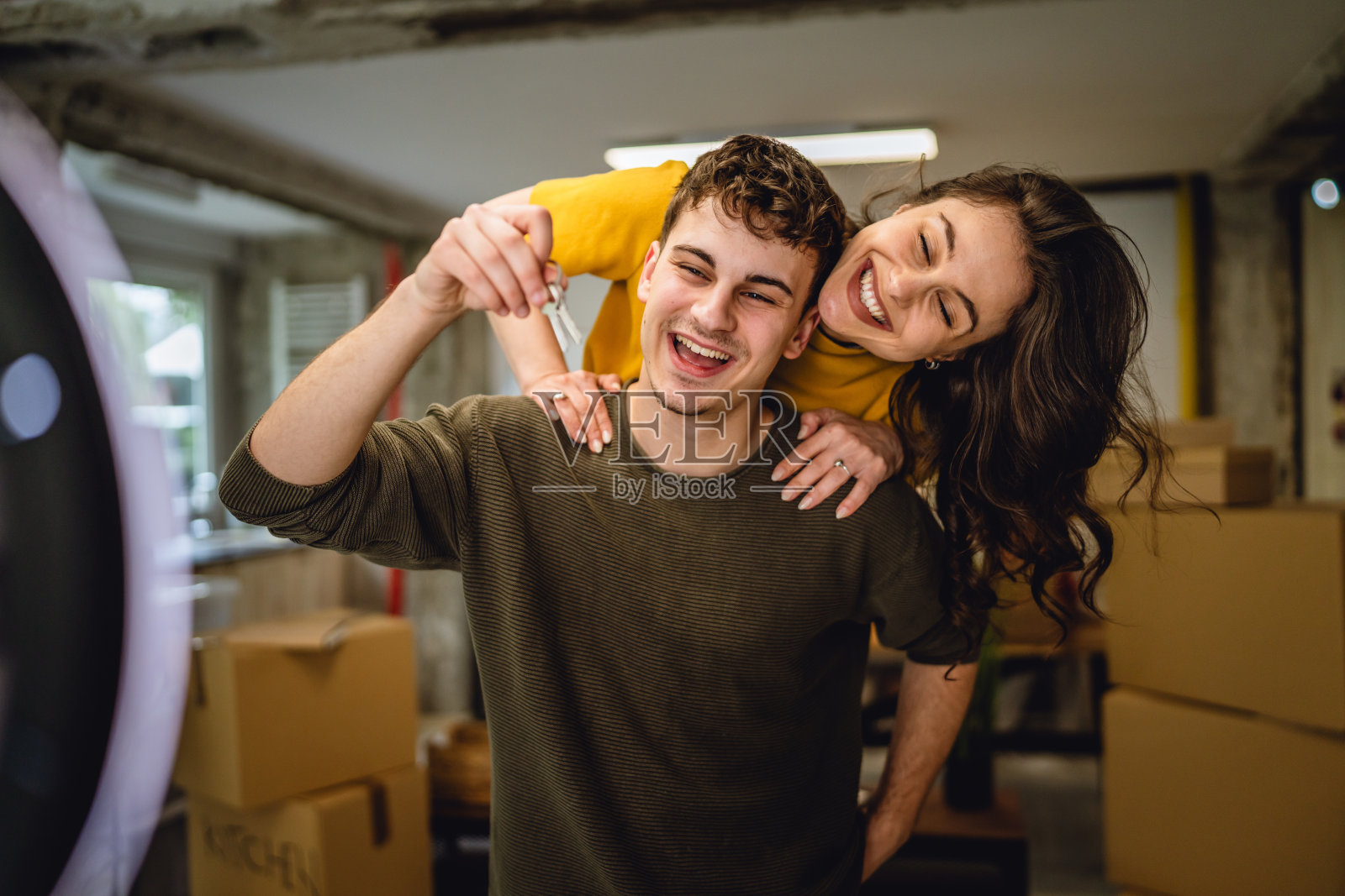 男女骑在背上录制视频并展示新家的钥匙照片摄影图片