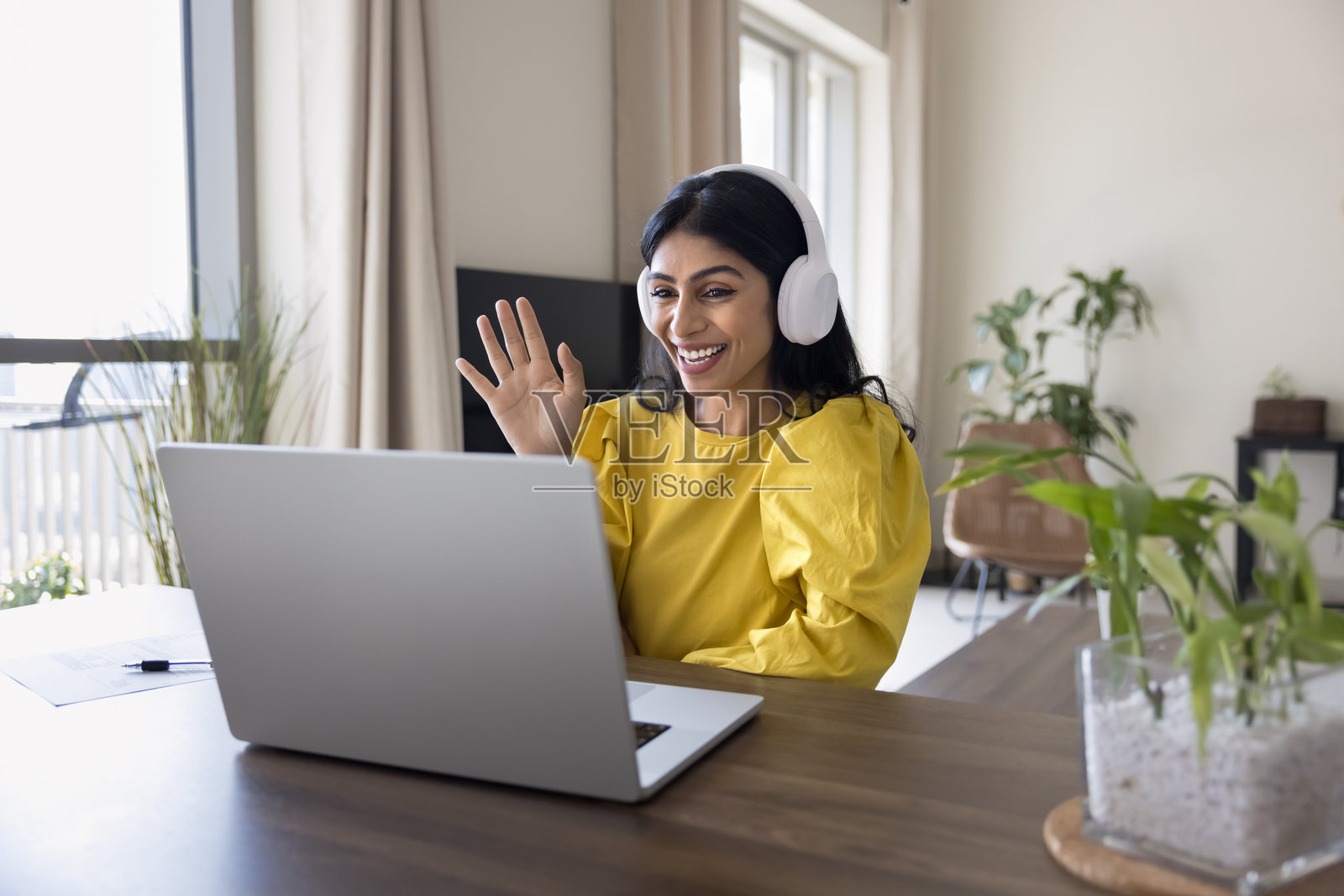快乐的年轻印度女企业家在笔记本电脑前挥手问好照片摄影图片