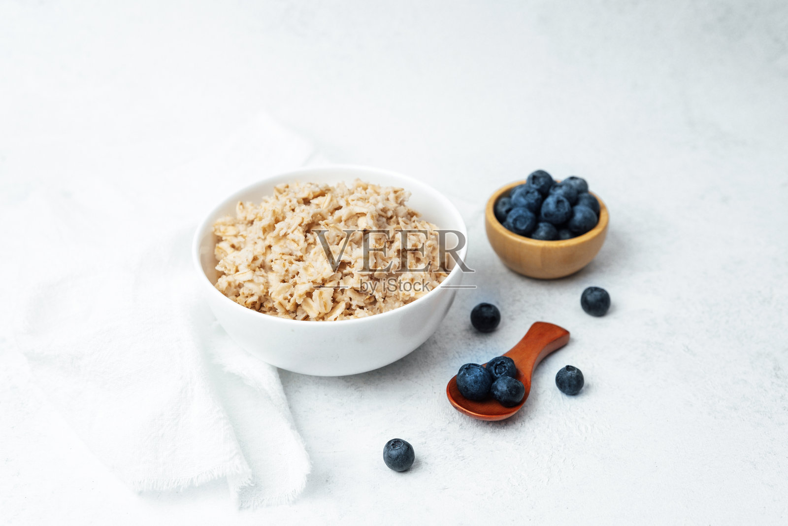 燕麦粥配新鲜蓝莓，摆放在干净简约的环境中照片摄影图片