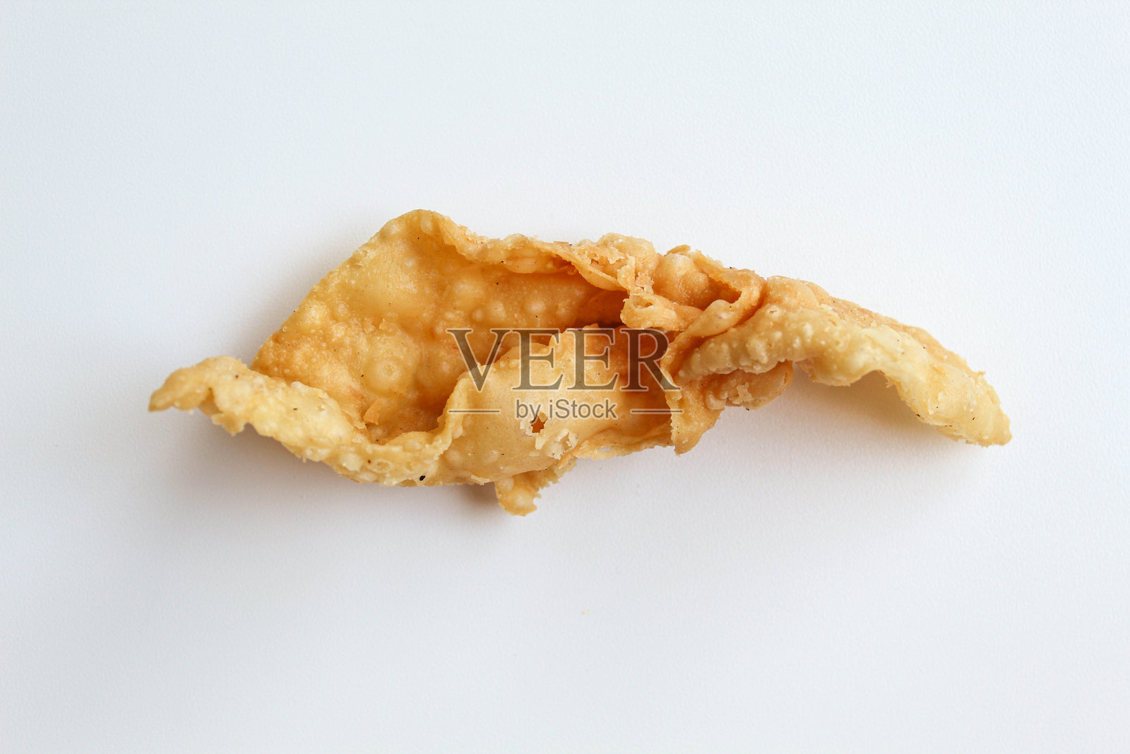 一块独立在白色背景上的脆皮饺子（Kerupuk pangsit）照片摄影图片