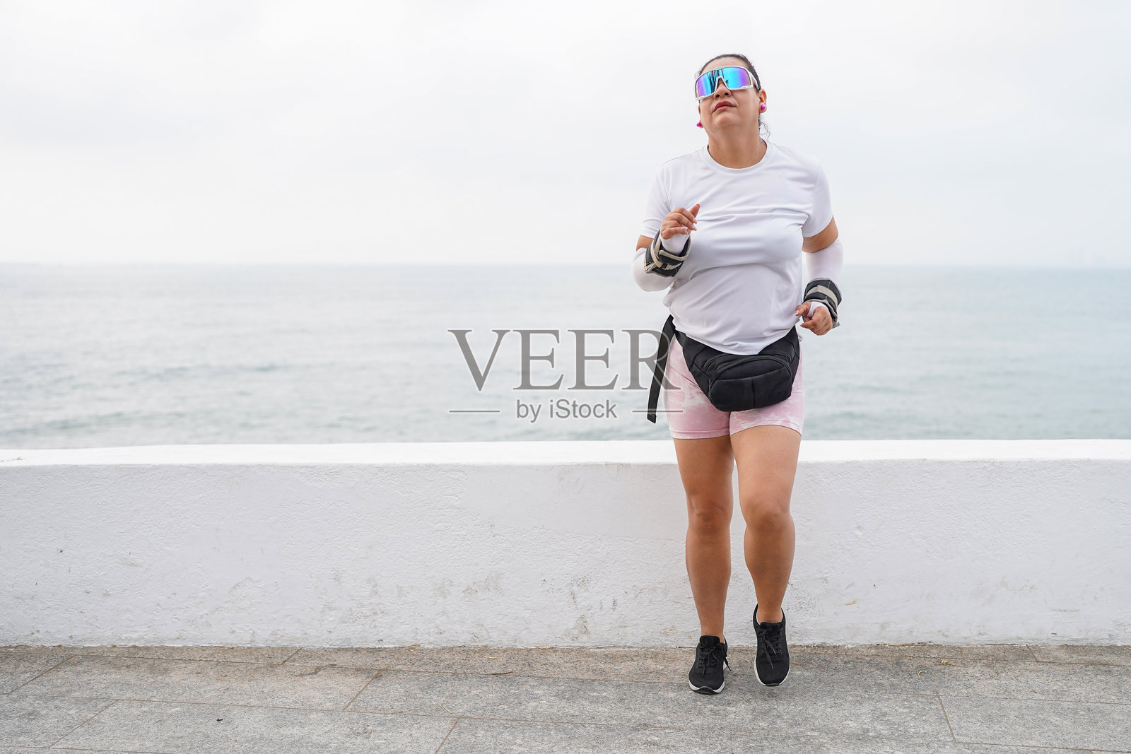 曲线优美的拉丁裔女性在海边跑步，享受她的锻炼时光照片摄影图片