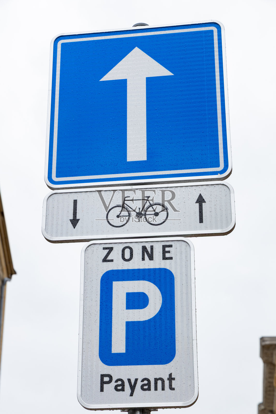 城市环境中，位于一座历史悠久的石建筑旁的方向交通标志和停车区标志照片摄影图片