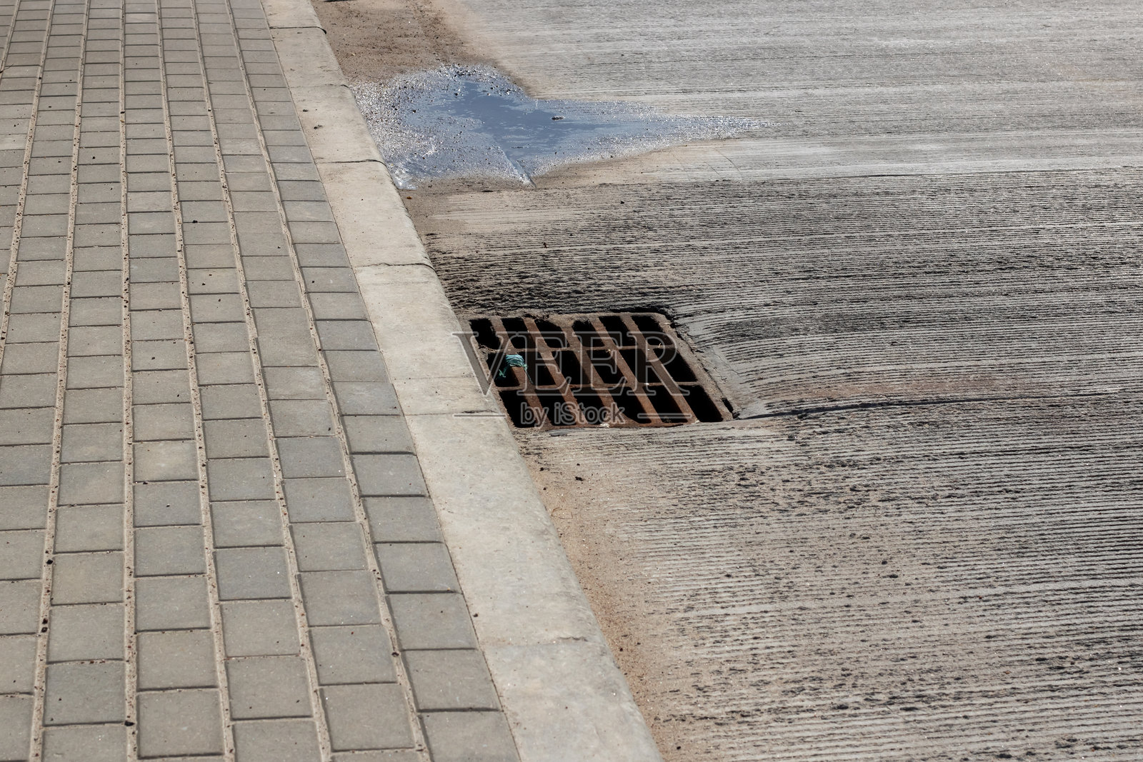 路边的排水沟正在排放水，采用复合材料制成。照片摄影图片
