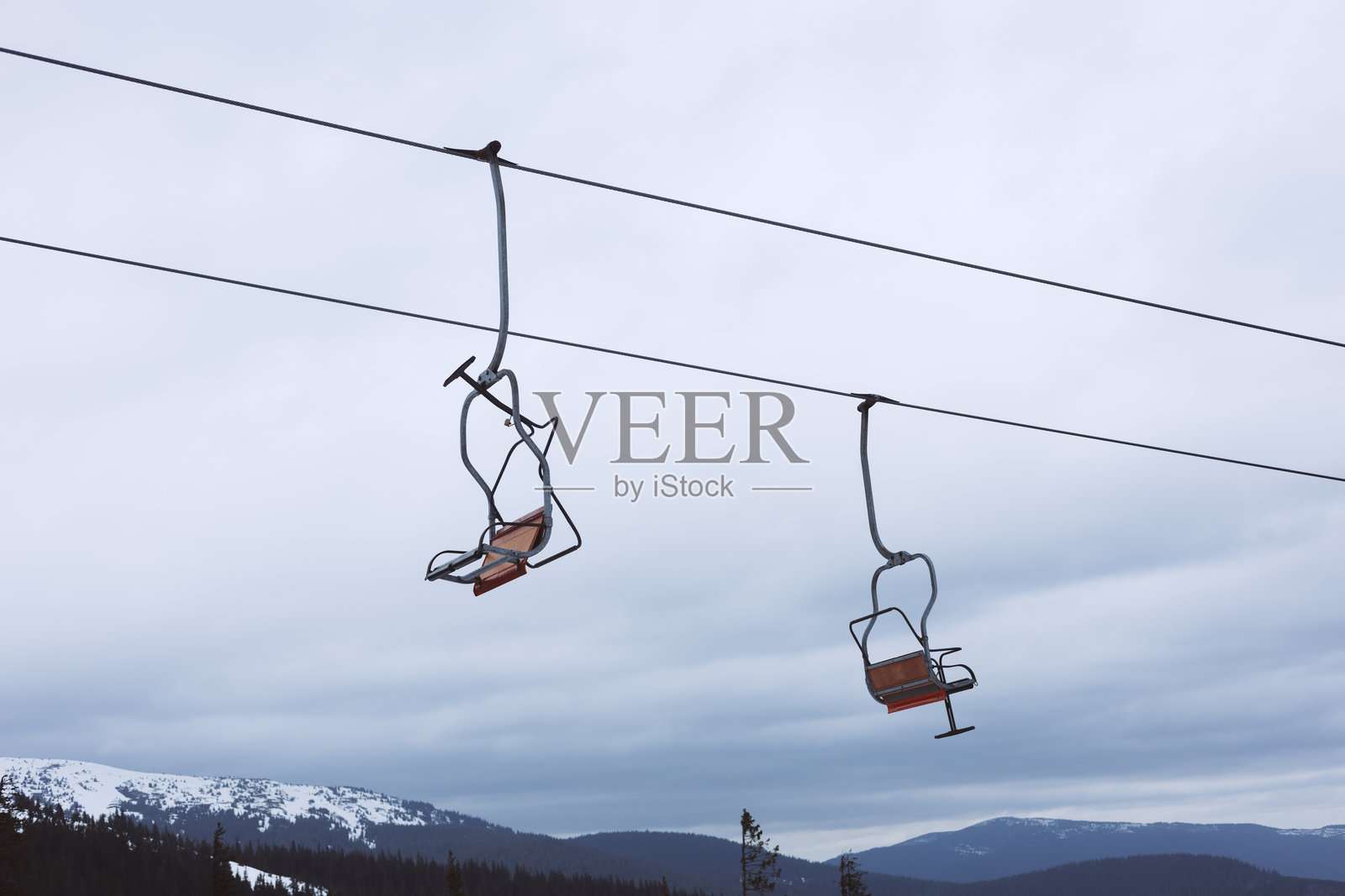 一把空的滑雪缆车悬挂在雪白的景色上照片摄影图片