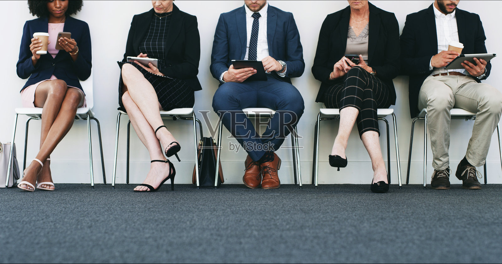 商务人士在办公室的候诊室里排队等待工作机会、会议或职业搜索。员工们在使用技术进行在线申请、经验分享或入职流程。照片摄影图片