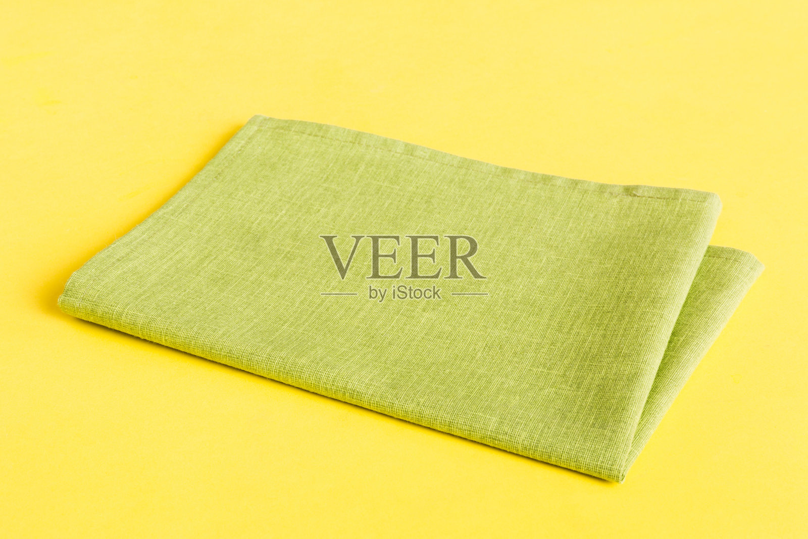 顶部视角，绿色厨房餐巾纸孤立在桌面背景上。折叠的布料用于展示，留有空白空间，平铺式。极简风格。照片摄影图片