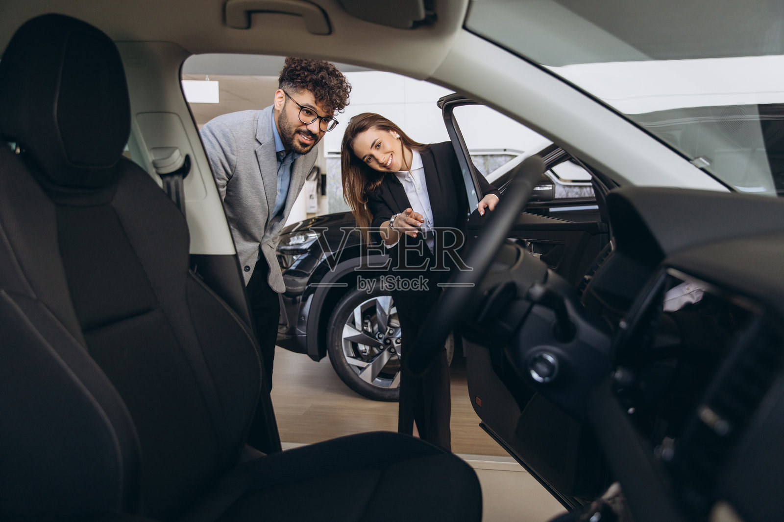 汽车经销商在汽车展厅向客户展示新车照片摄影图片