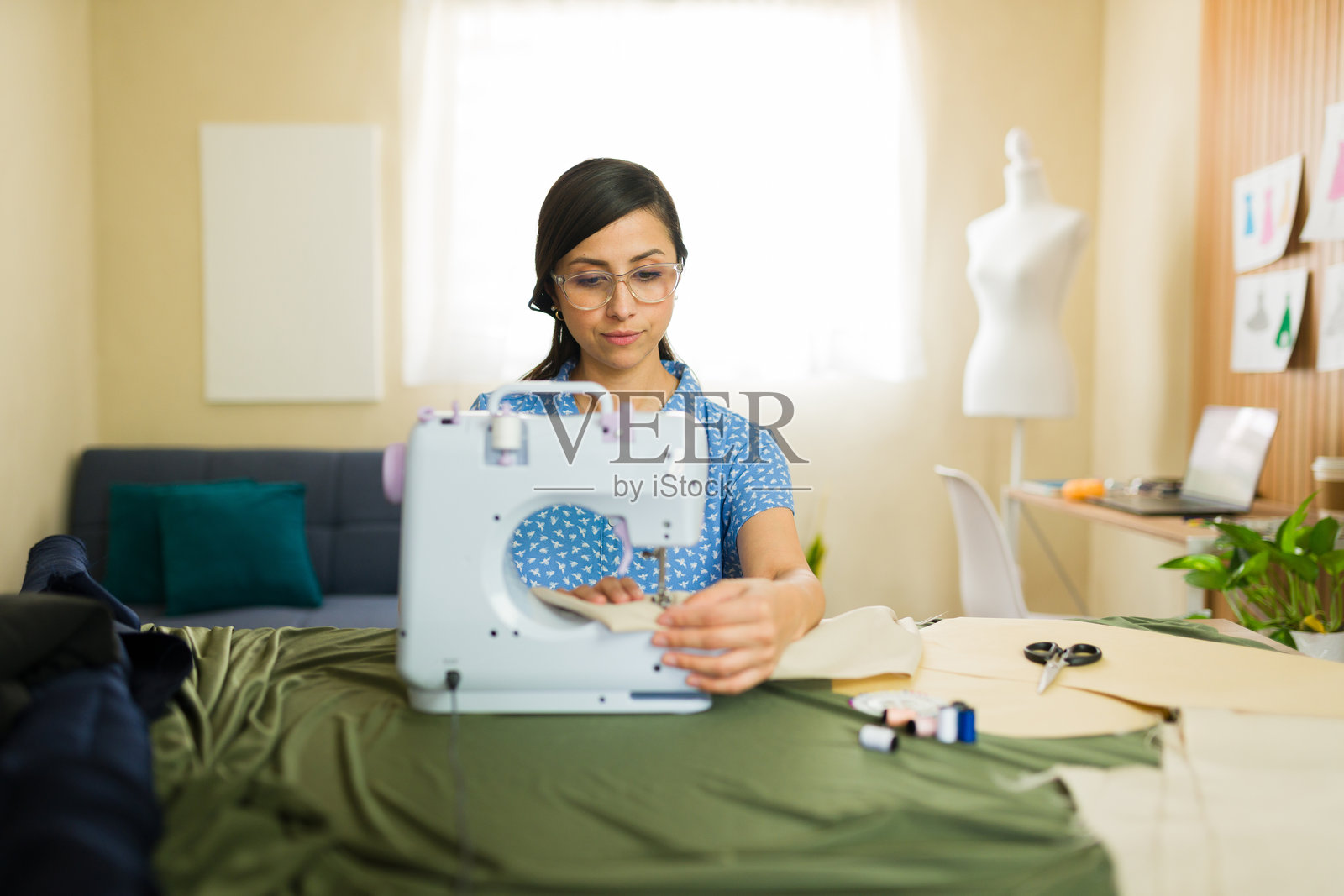 时尚设计师在家用缝纫机缝制面料照片摄影图片
