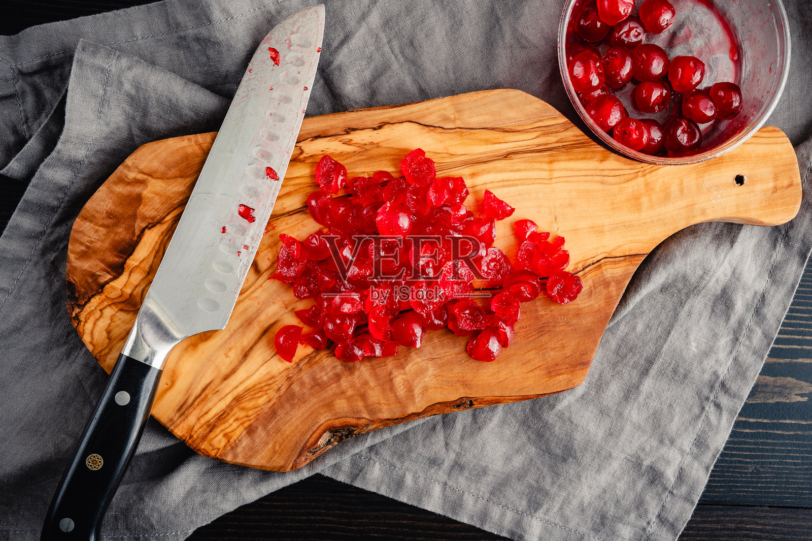 切碎的糖渍樱桃放在木砧板上照片摄影图片