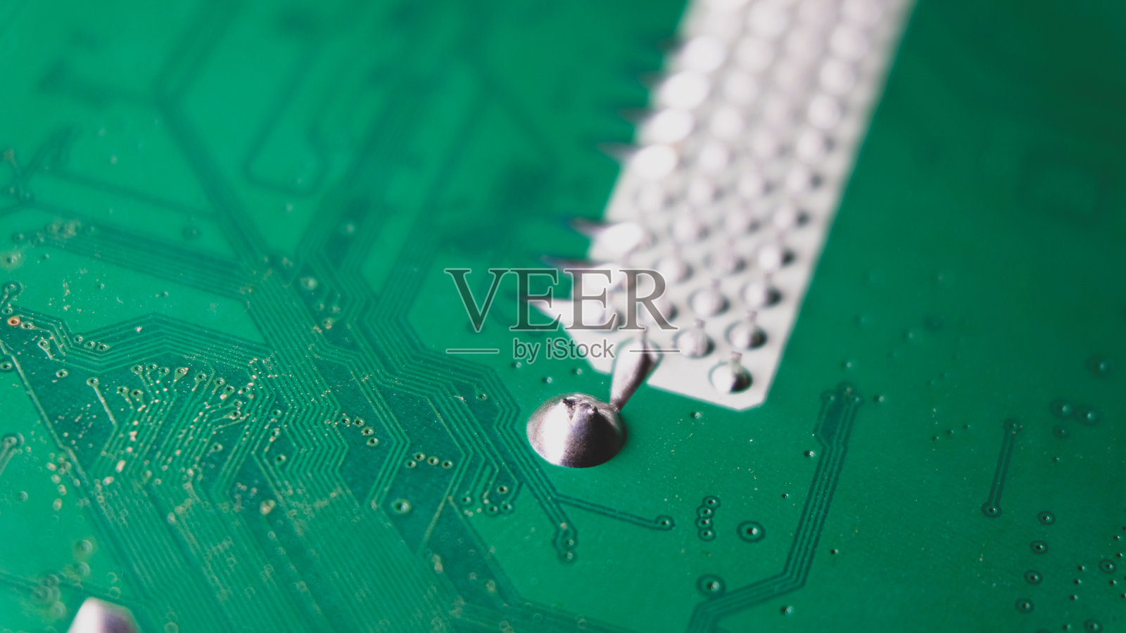 电路板特写，绿色PCB线路，焊接引脚，银色照片摄影图片