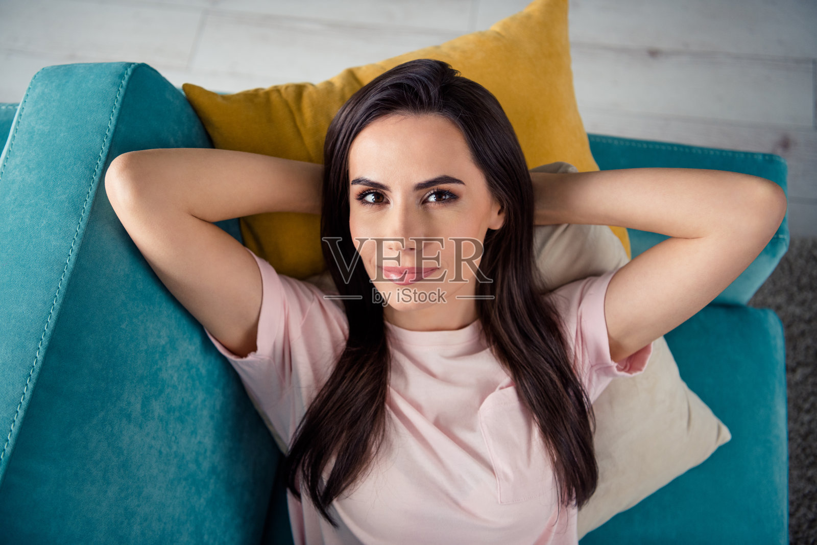 高角度拍摄的安静女士躺在沙发上，享受在新客厅家具中放松休息的时光。照片摄影图片