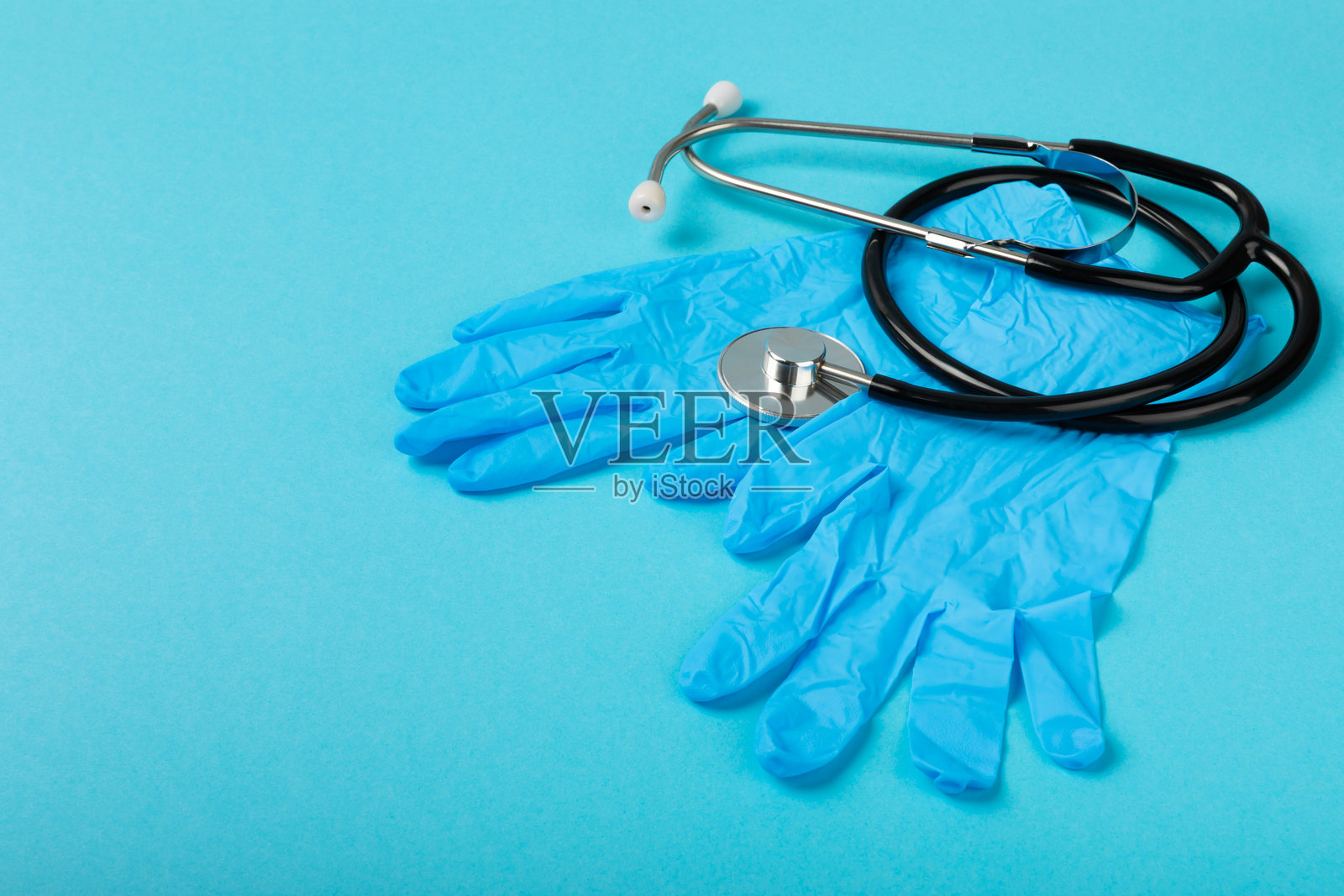 医用丁腈手套，蓝色帽子，一次性医用口罩，背景有纹理。医护防护服。外科乳胶手套。橡胶手套制造。医学概念。俯视图。复制文本。照片摄影图片