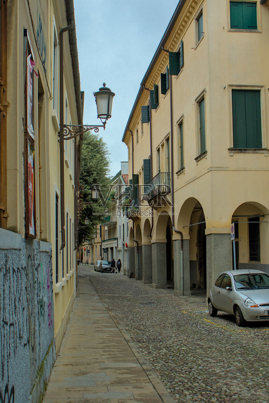 意大利帕多瓦一条迷人的狭窄街道，展示了拱形通道和古老建筑的历史建筑风貌。照片摄影图片