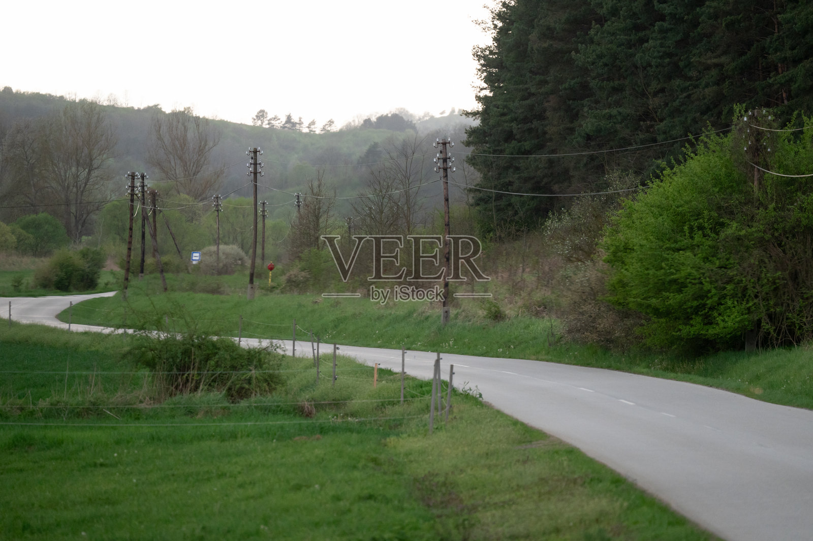 黄昏时分蜿蜒的乡村道路穿过绿色的风景照片摄影图片