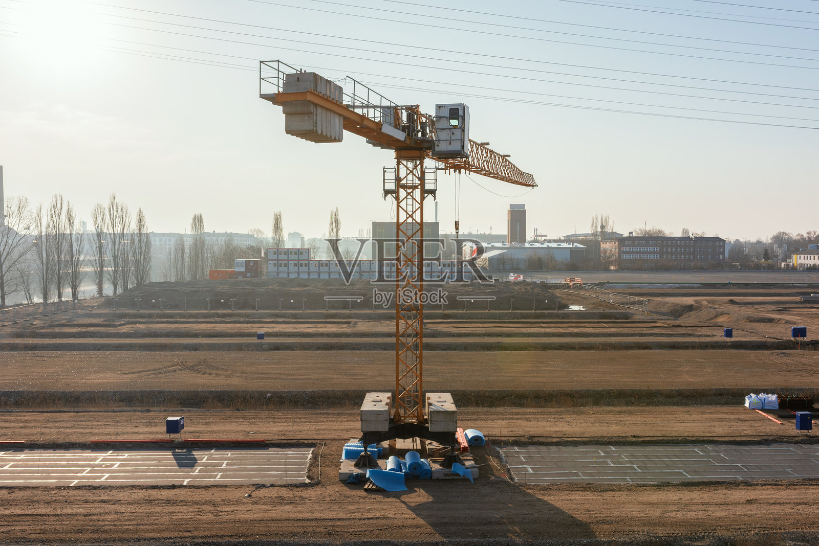 黄色塔吊矗立在宽阔平坦的建筑工地中央照片摄影图片