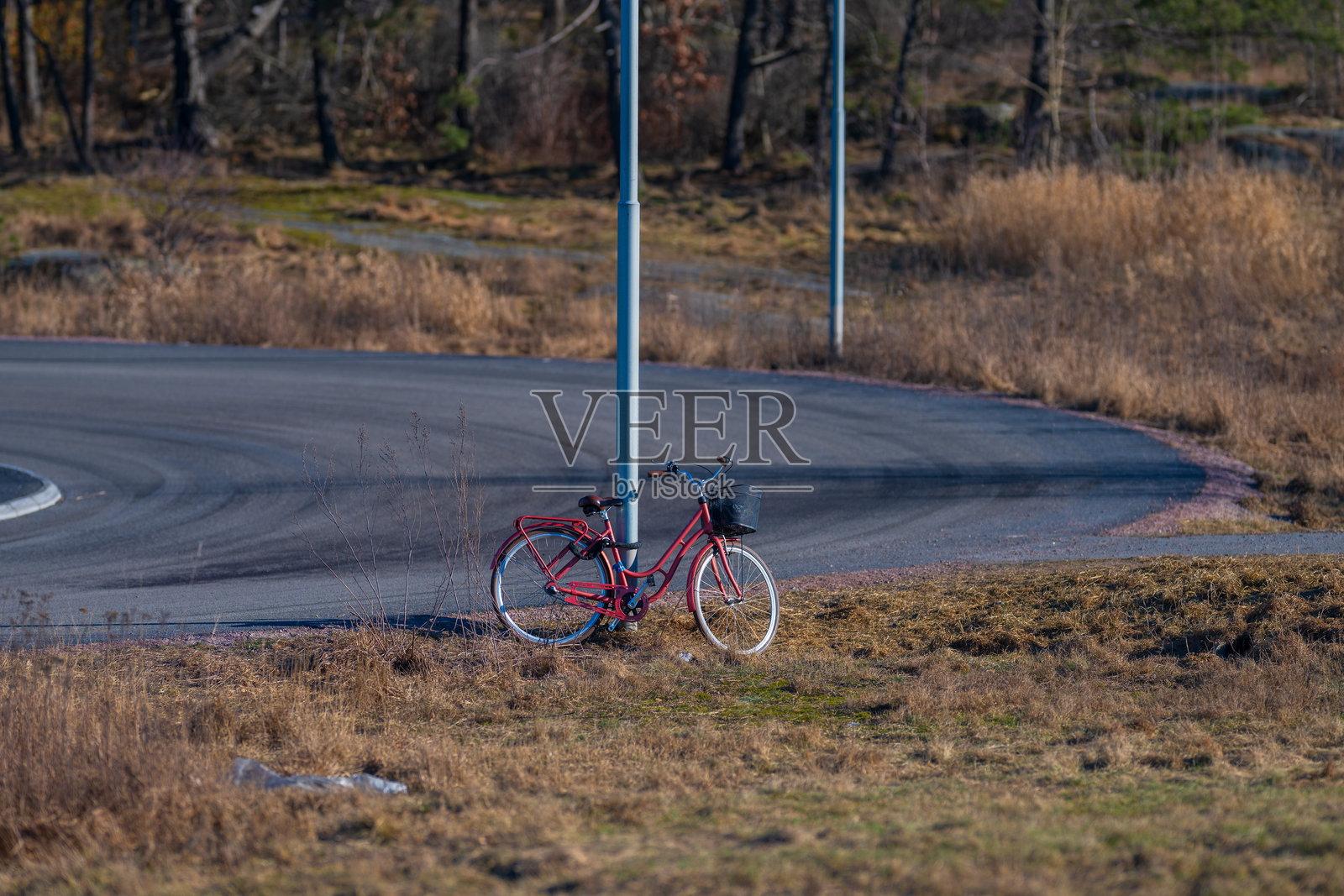 乡村道路旁被遗弃的红色自行车。照片摄影图片