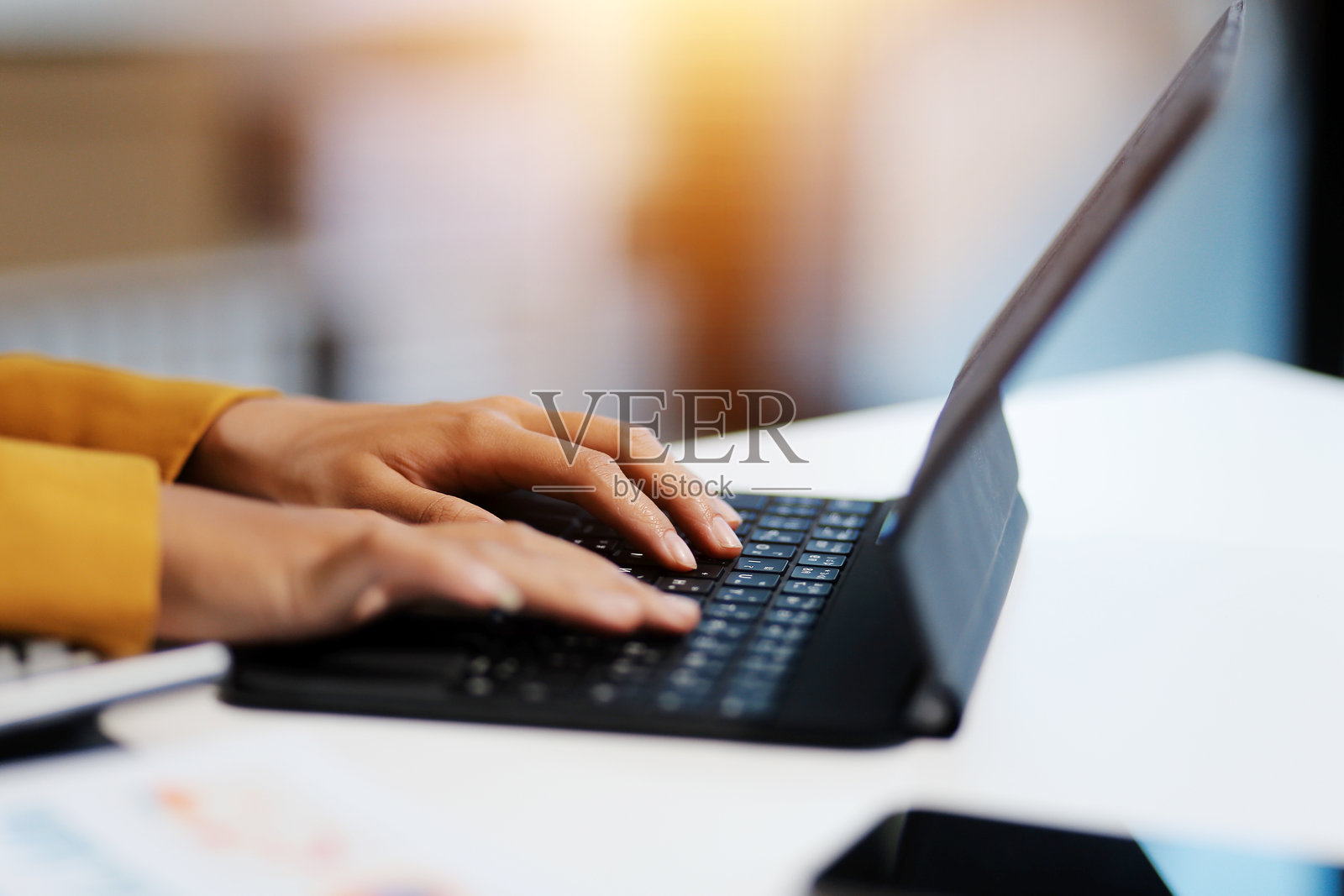 微笑的美丽亚洲女性在办公室使用电脑的肖像，留有空白空间。商业拥有者、自由职业者、在线营销、电子商务、电话营销，居家办公概念。照片摄影图片