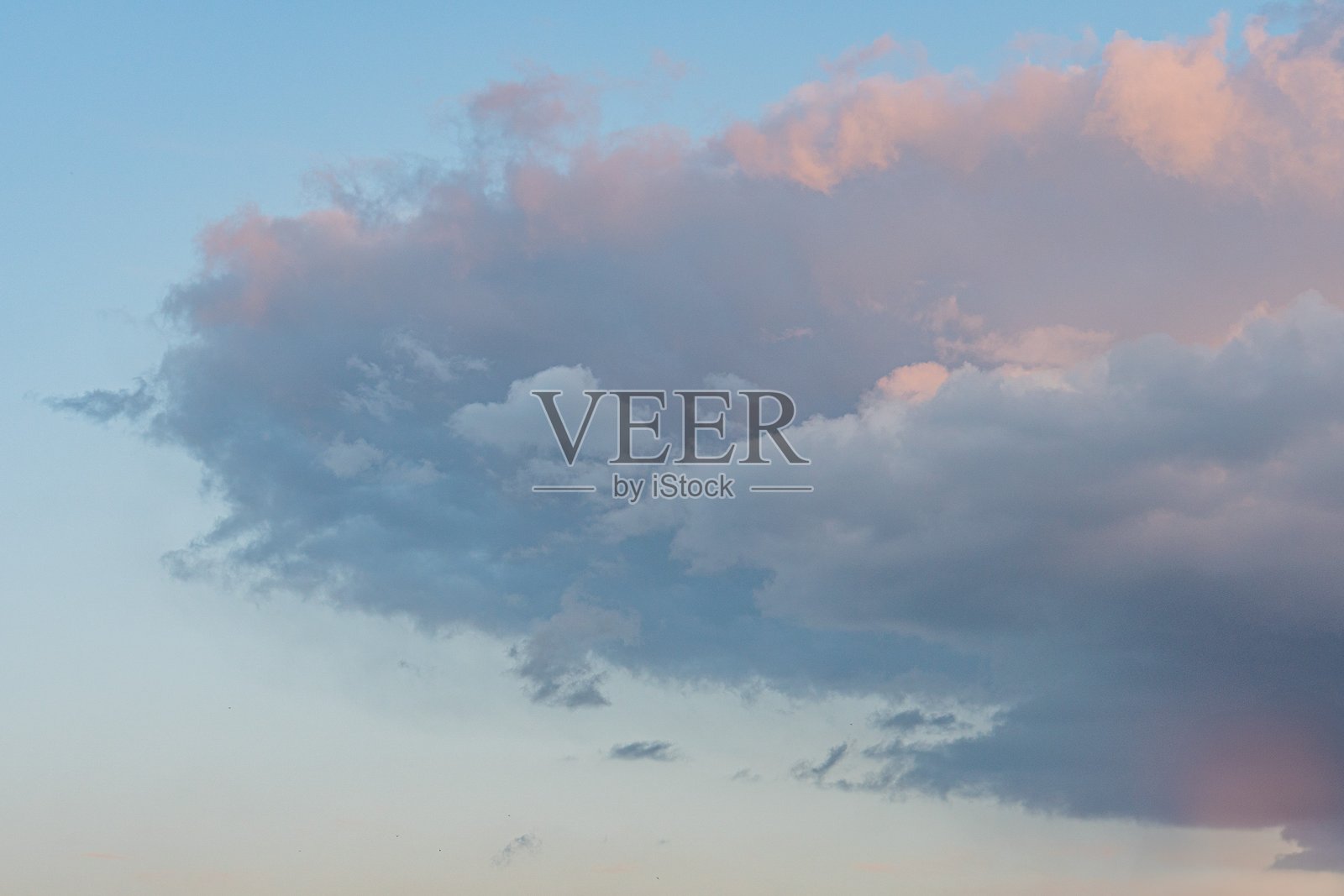 地面视角的日落，主导的蓬松云朵和引人入胜的阴影，天空被粉色、紫色和蓝色的色调渲染，写实风格，色彩鲜艳，除了云朵外没有其他文本或物体可见。照片摄影图片