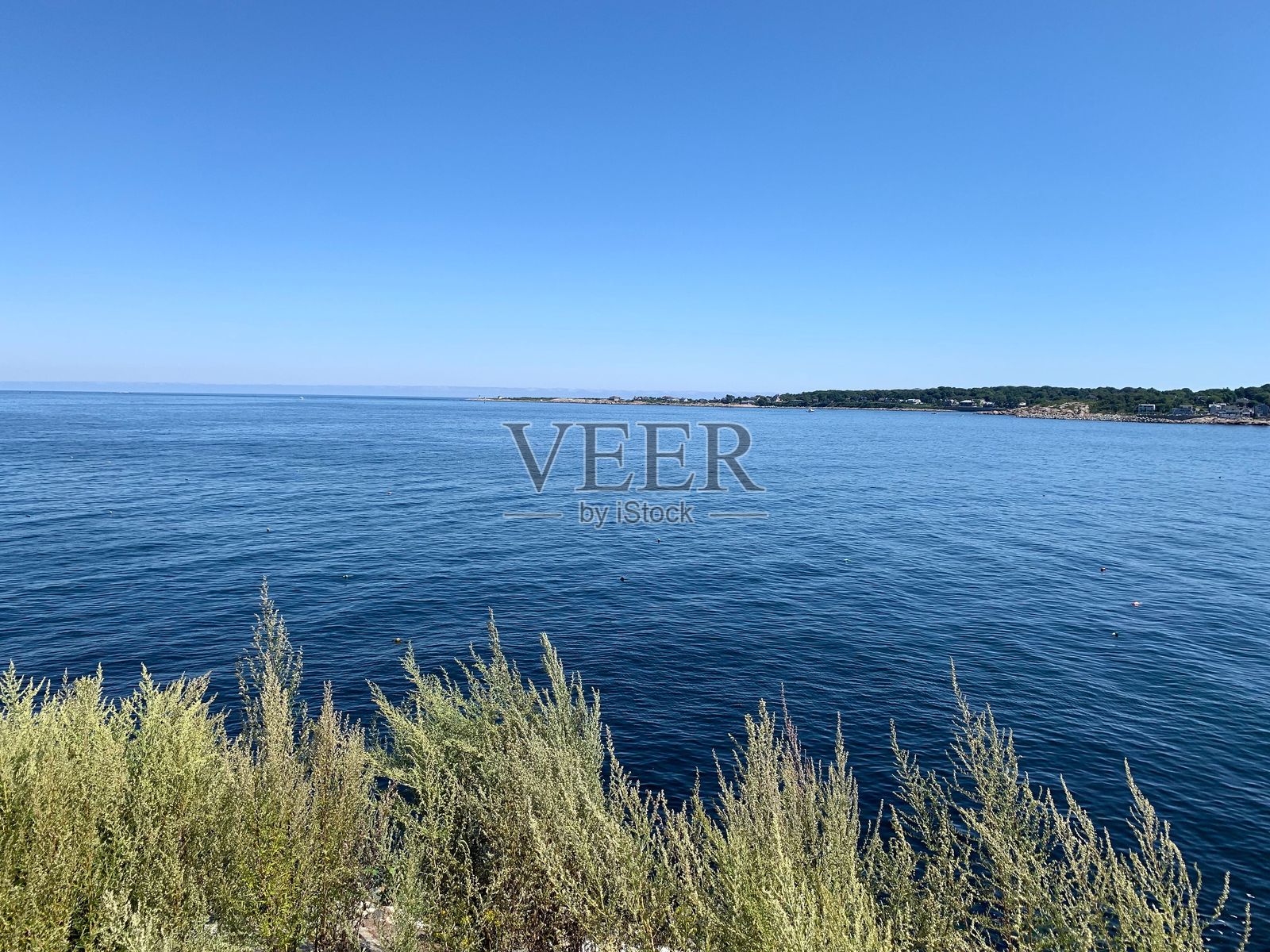 马萨诸塞州洛克波特的风景如画的海岸线，清澈的蓝色海水和遥远的海岸线。照片摄影图片