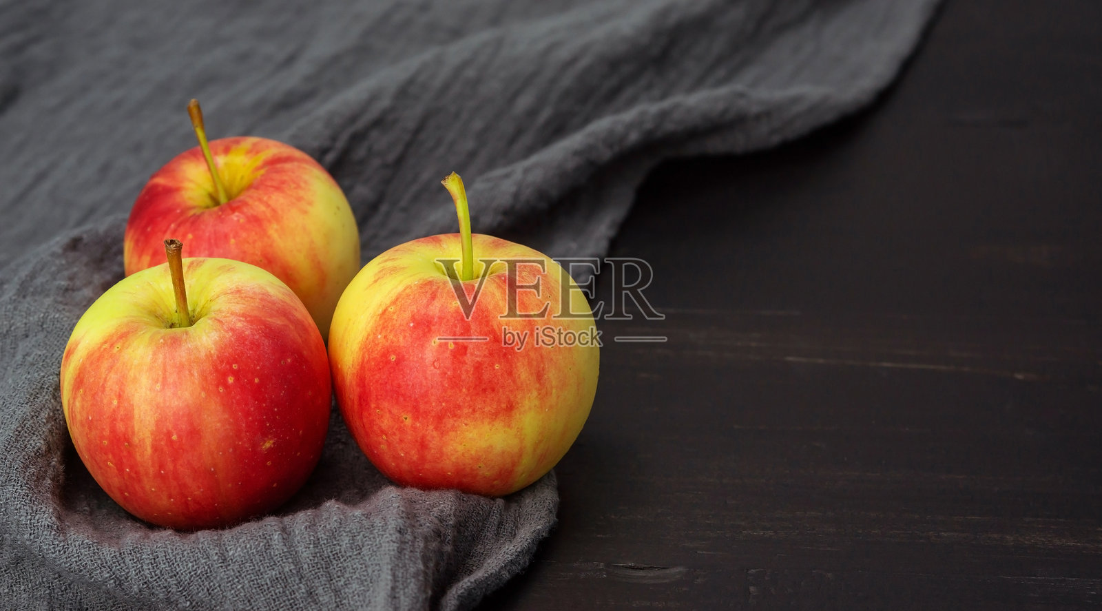 黑色木桌上的红苹果。照片摄影图片