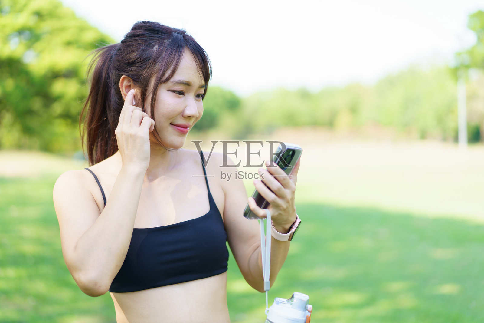 亚洲女性使用智能手表或追踪器来跟踪她的锻炼进度。照片摄影图片