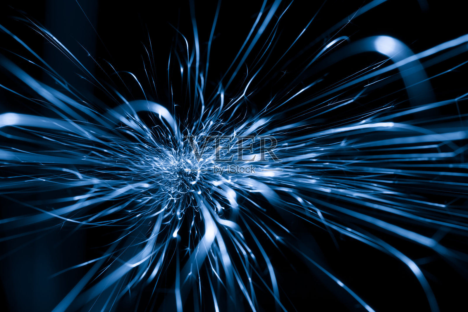 在黑暗中闪烁的蓝色火花来自磨床照片摄影图片