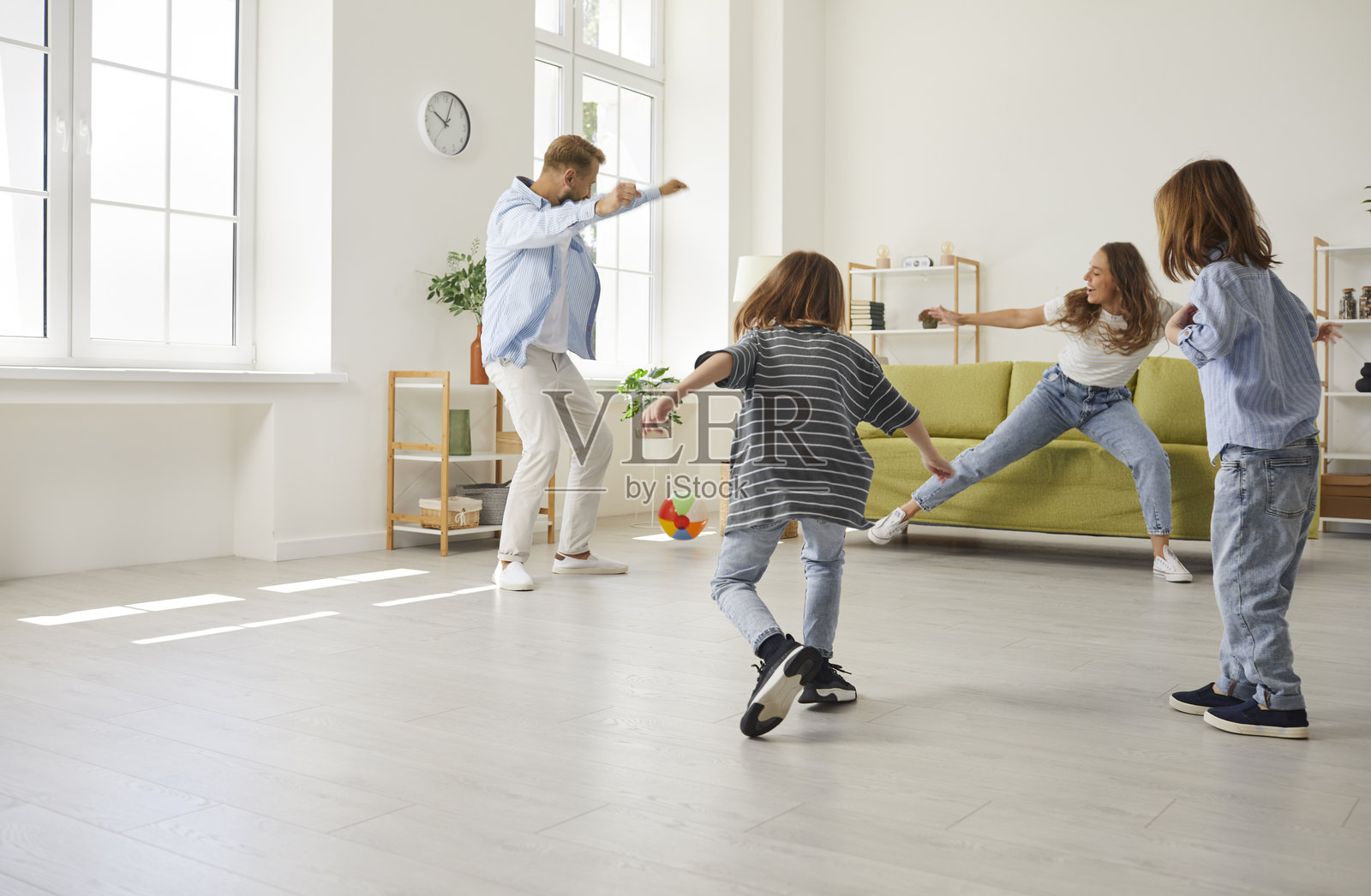 快乐的家庭与孩子们在家里踢足球照片摄影图片