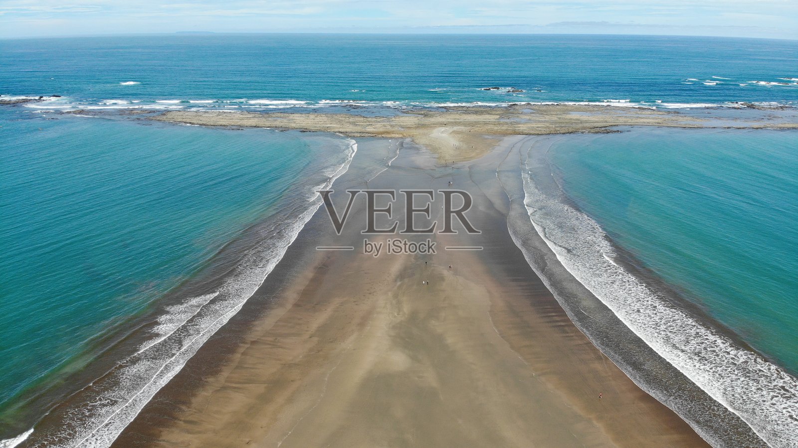 哥斯达黎加中美洲马里诺·巴耶纳国家公园内，独特的半岛形状像鲸鱼的尾巴的无人机航拍图像。对称的海滩和沙洲，蓝色的水面和小浪潮。自然与风景摄影。照片摄影图片