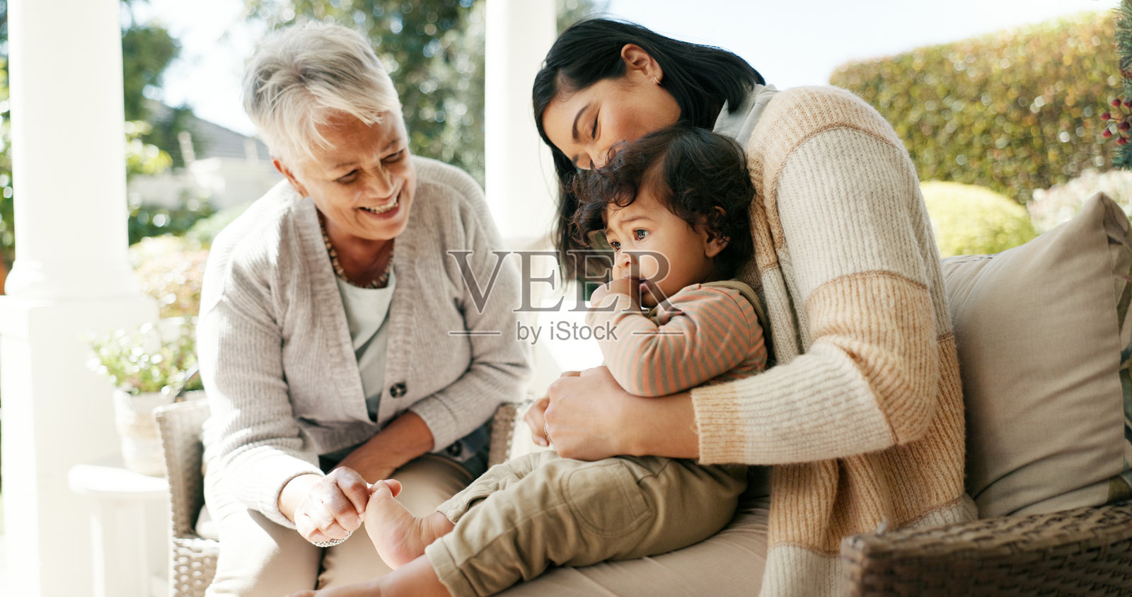 在沙发上与家人一起享受爱、放松和陪伴，增进亲密关系和祖辈的支持。在家中的客厅里，女性和孩子之间的关爱、幸福和联系，体现了共同的承诺、成长和信任。照片摄影图片