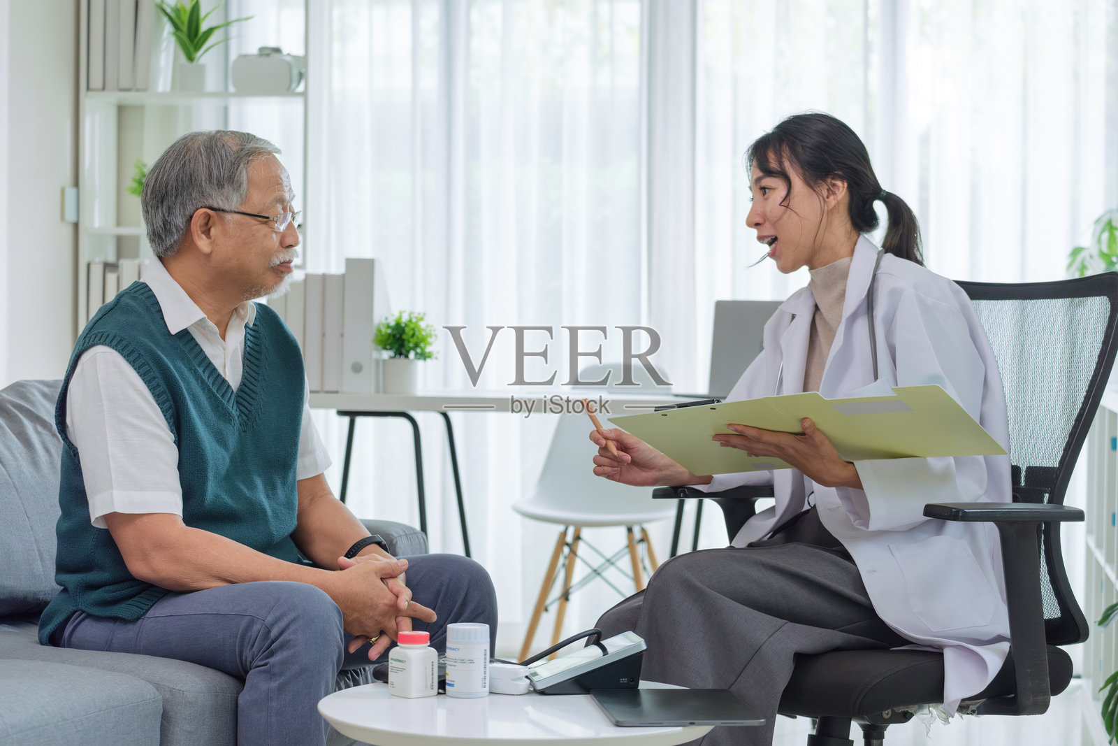 医生在诊所或医院采访老年患者时审阅病历文件照片摄影图片