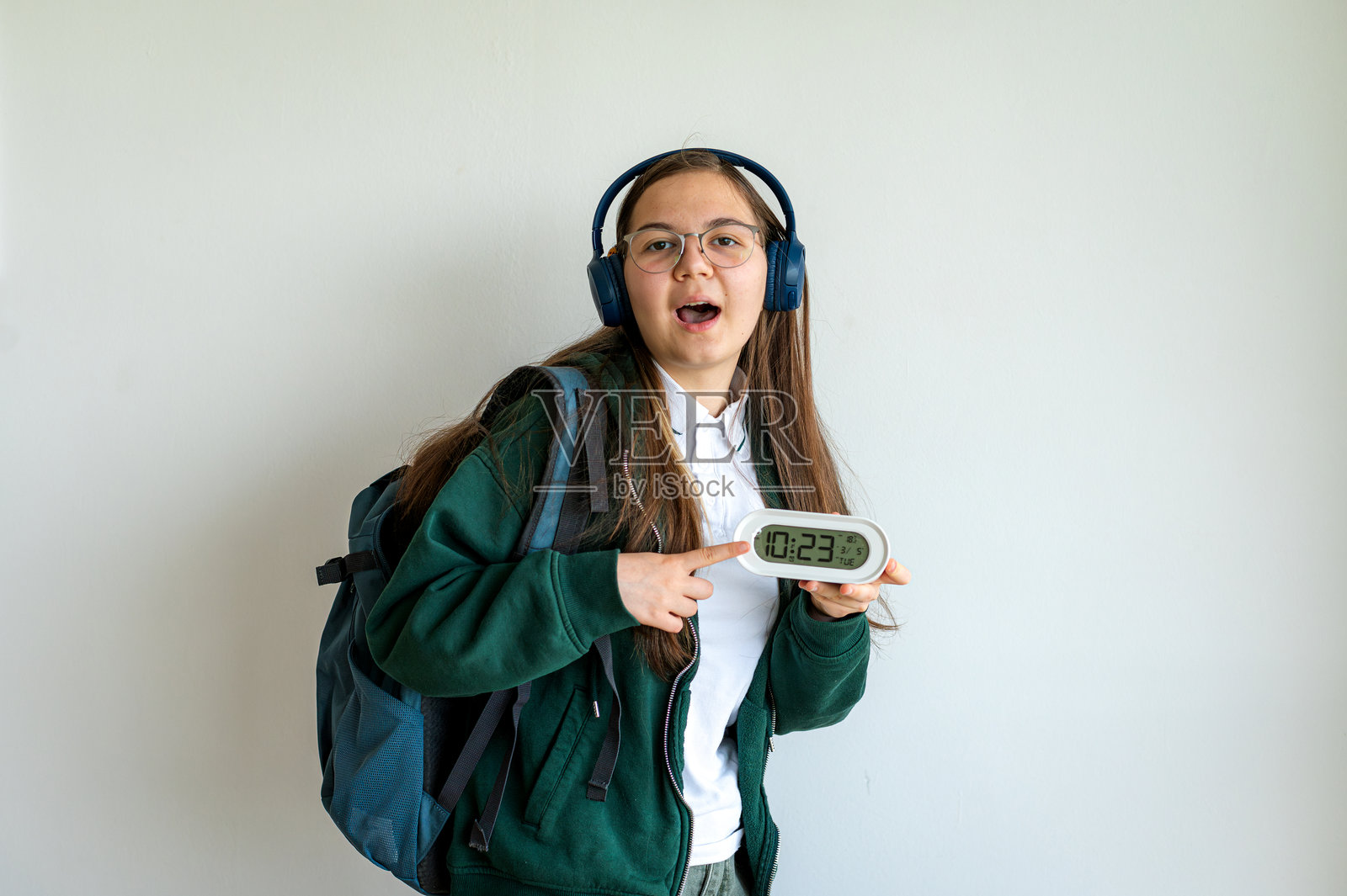 白色背景下的青少年学生手持时钟照片摄影图片