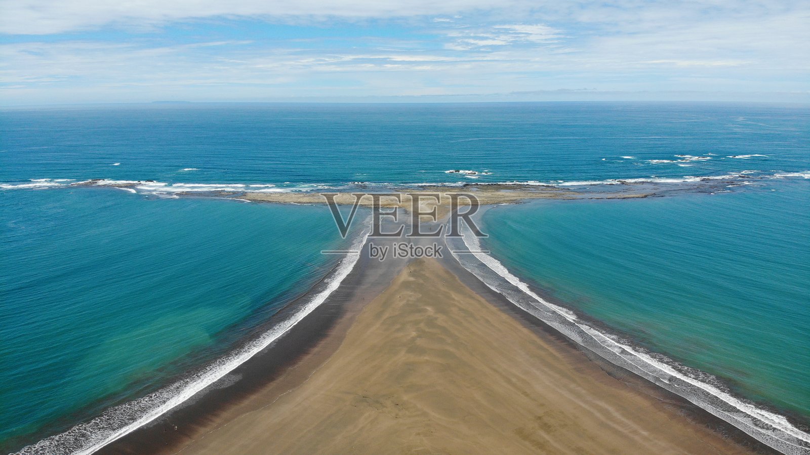 哥斯达黎加中美洲马里诺巴耶纳国家公园内，独特的半岛形状像鲸鱼的尾巴的无人机航拍图像。对称的海滩和沙洲，蓝色的海水和小浪潮。自然与风景摄影。照片摄影图片