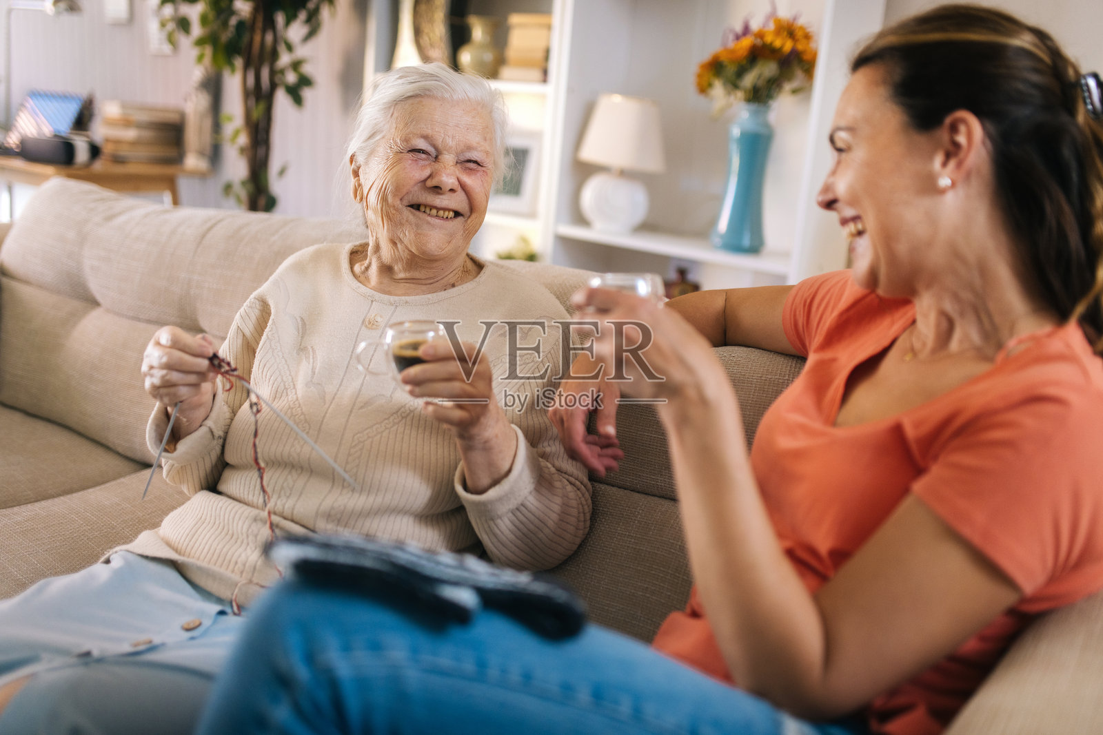 一位老年女性和她的女儿在家里的沙发上喝咖啡聊天的画面照片摄影图片