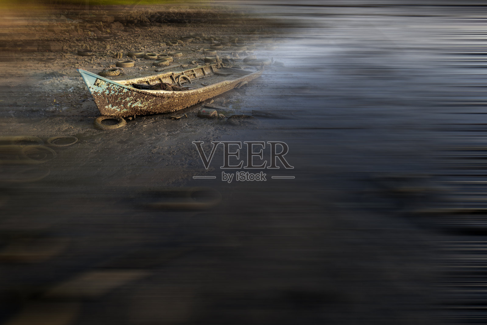 一只风化的蓝绿色小船停泊在平静的深色水面上。船的油漆剥落且磨损，暴露出底层材料。照片摄影图片